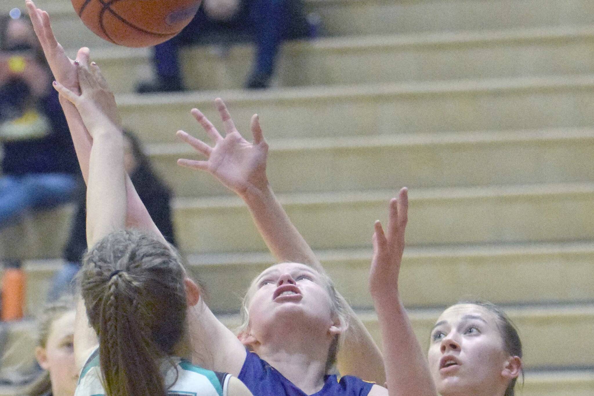 Homer's Sydney Shelby fights for a rebound between Nikiski's Shelby Burman and Rylee Ellis on Tuesday, Jan. 25, 2022, at Nikiski High School in Nikiski, Alaska. (Photo by Jeff Helminiak/Peninsula Clarion)