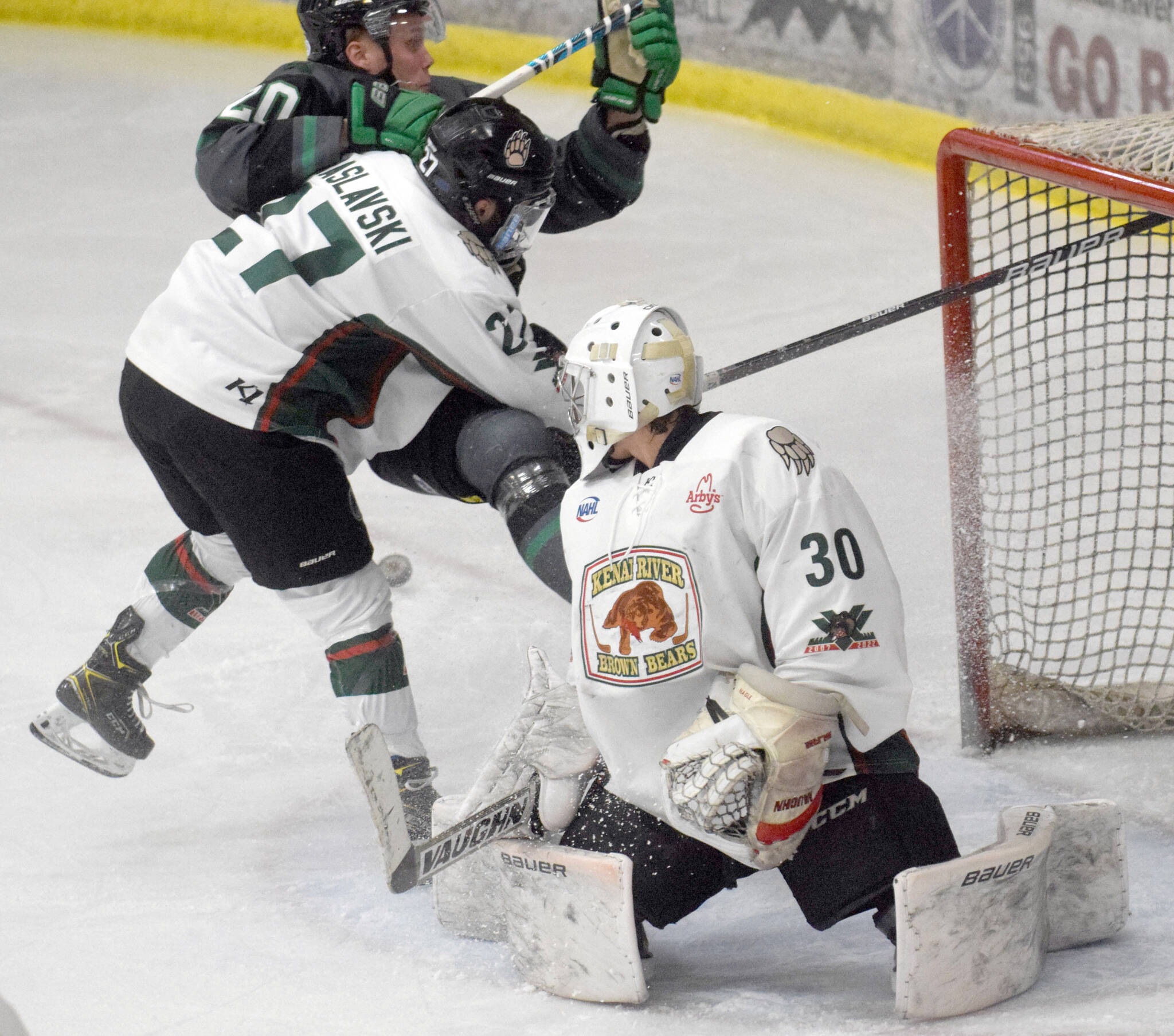 Kenai River Brown Bears forward Barak Braslavski checks Minnesota Wilderness forward William Persson behind Brown Bears goalie Bryant Marks on Thursday, March 17, 2022, at the Soldotna Regional Sports Complex in Soldotna, Alaska. (Photo by Jeff Helminiak/Peninsula Clarion)