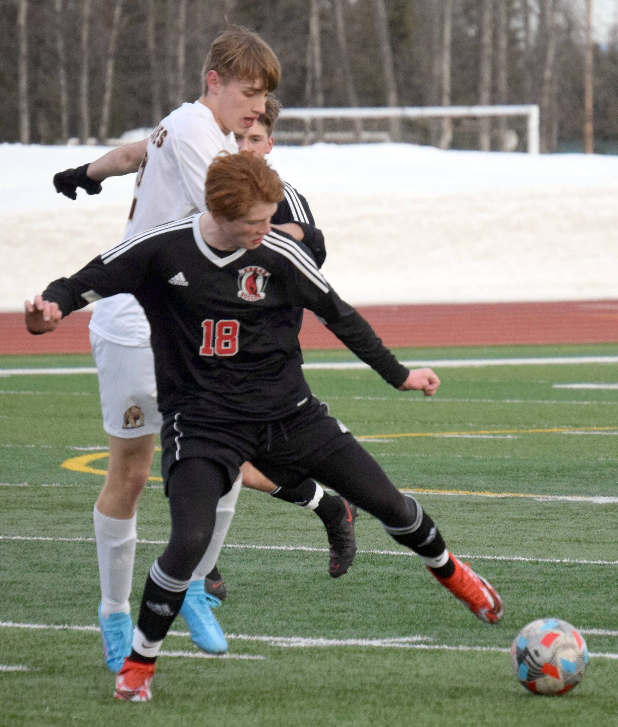 Kenai Central's Wade James and Grace Christian's Caden Nanninga battle for the ball Friday, April 1, 2022, at Kenai Central High School in Kenai, Alaska. (Photo by Jeff Helminiak/Peninsula Clarion)