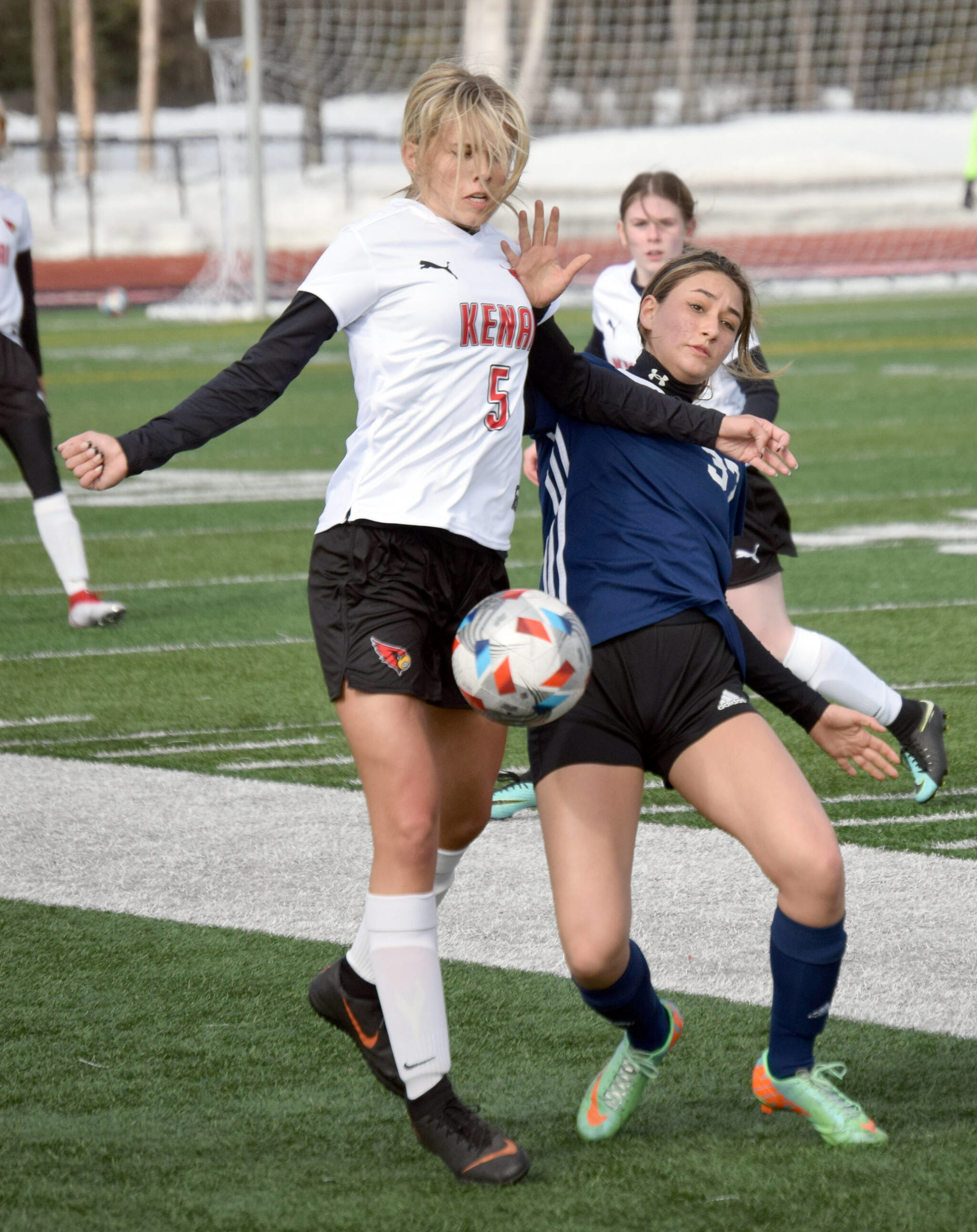 Kenai Central’s Chloe Goldsby and Soldotna’s Zayra Poage battle for the ball Friday, April 8, 2022, at Kenai Central High School in Kenai, Alaska. (Photo by Jeff Helminiak/Peninsula Clarion)