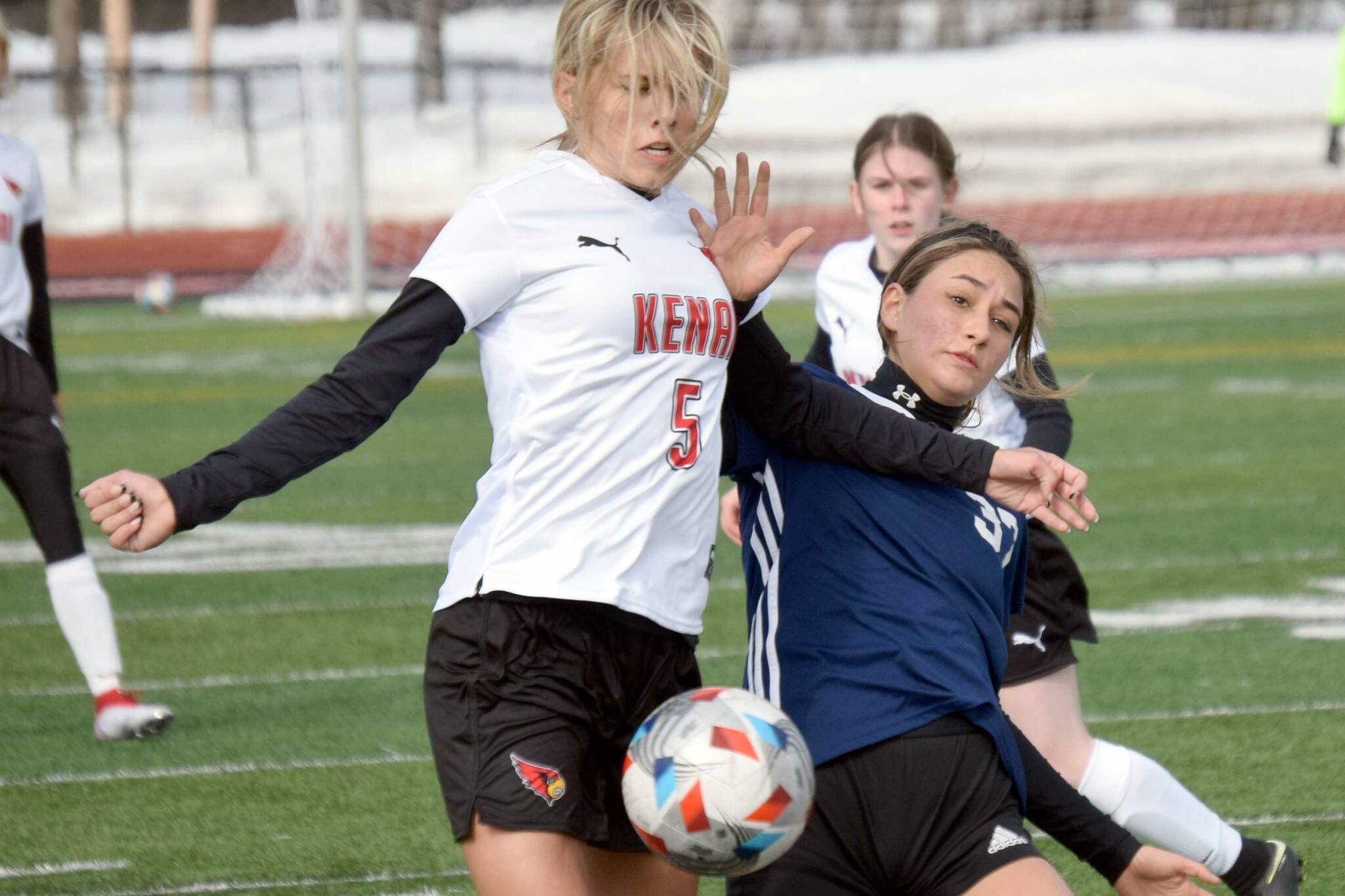 Kenai Central's Chloe Goldsby and Soldotna's Zayra Poage battle for the ball Friday, April 8, 2022, at Kenai Central High School in Kenai, Alaska. (Photo by Jeff Helminiak/Peninsula Clarion)