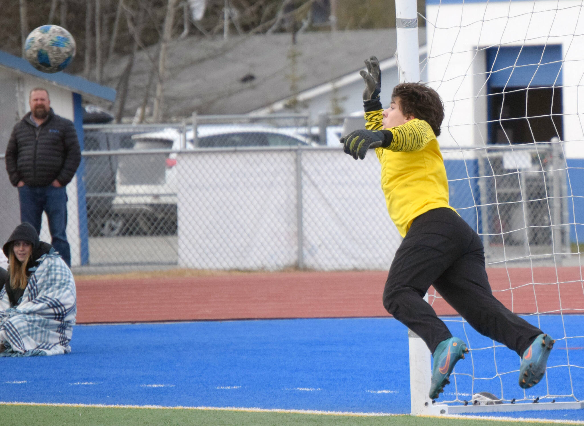 A first half free kick by Kenai Central’s Joe Hamilton barely eludes the grasp of Soldotna goalie Gehret Medcoff on Tuesday, May 3, 2022, at Justin Maile Field at Soldotna High School in Soldotna, Alaska. (Photo by Jeff Helminiak/Peninsula Clarion)