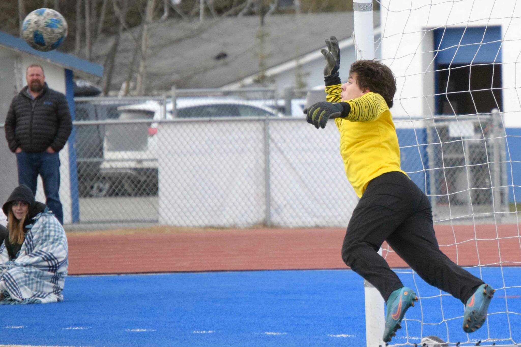 A first half free kick by Kenai Central's Joe Hamilton barely eludes the grasp of Soldotna goalie Gehret Medcoff on Tuesday, May 3, 2022, at Justin Maile Field at Soldotna High School in Soldotna, Alaska. (Photo by Jeff Helminiak/Peninsula Clarion)