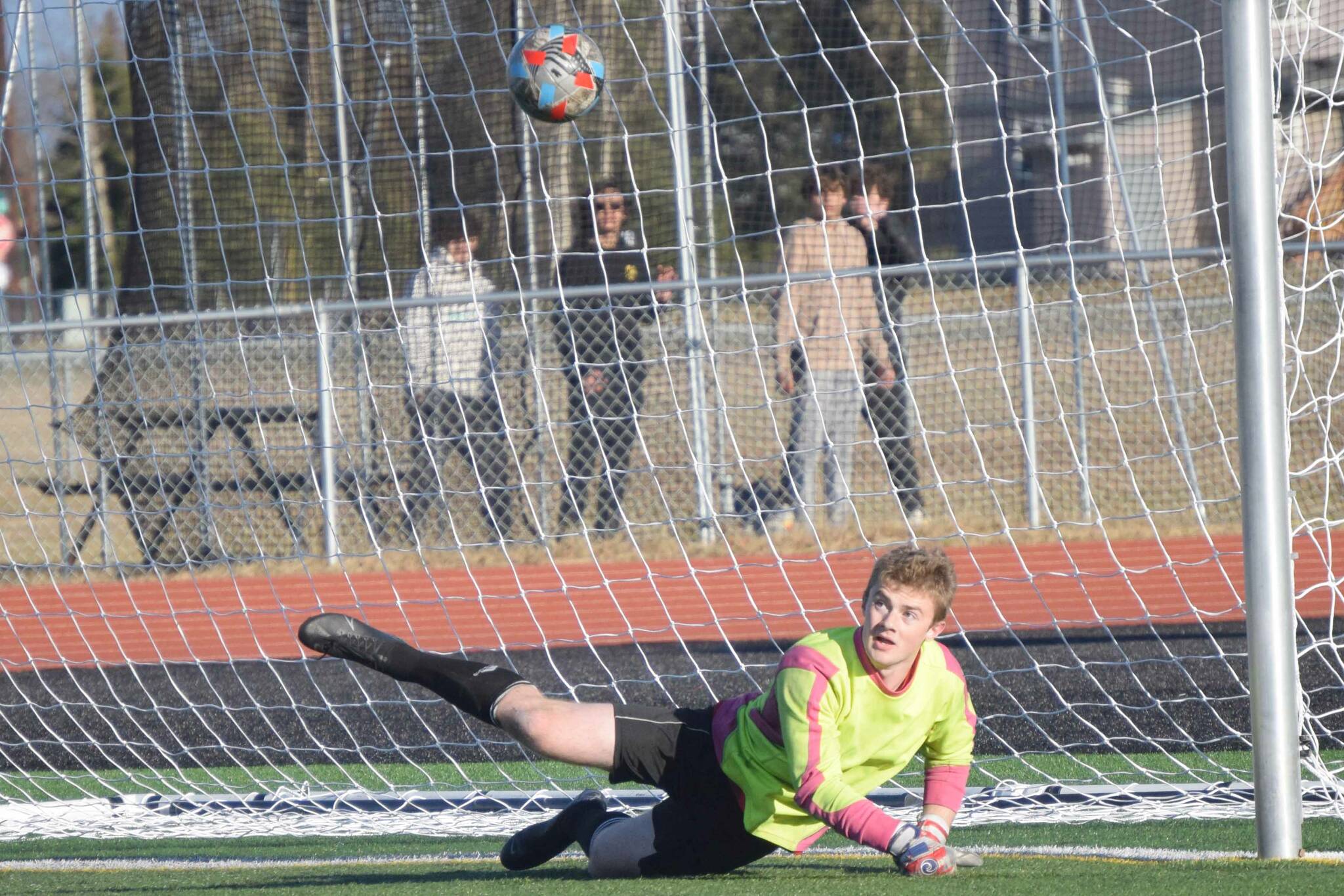 Kenai Central goalie Gavin Langham saves a penalty kick against Dimond on Friday, May 6, 2022, at Ed Hollier Field at Kenai Central High School in Kenai, Alaska. (Photo by Jeff Helminiak/Peninsula Clarion)