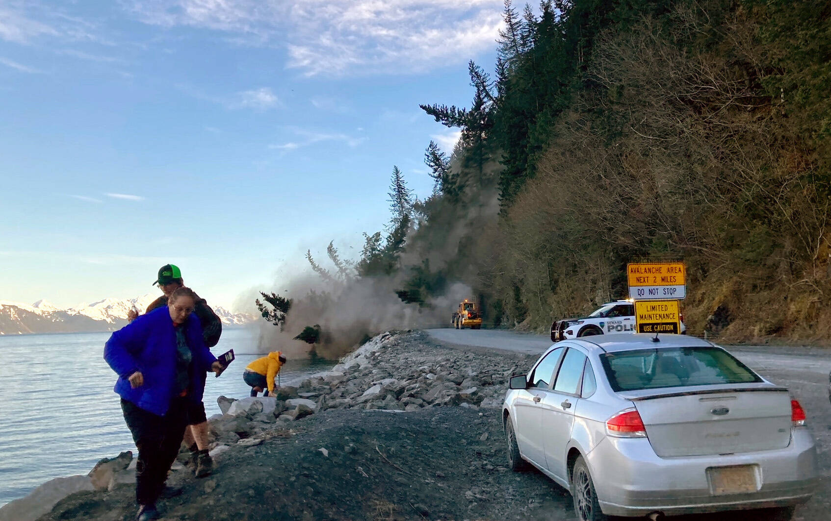 People run from a landslide just outside the downtown area of Seward, Alaska, May 7, 2022. (Josh Gray via AP)