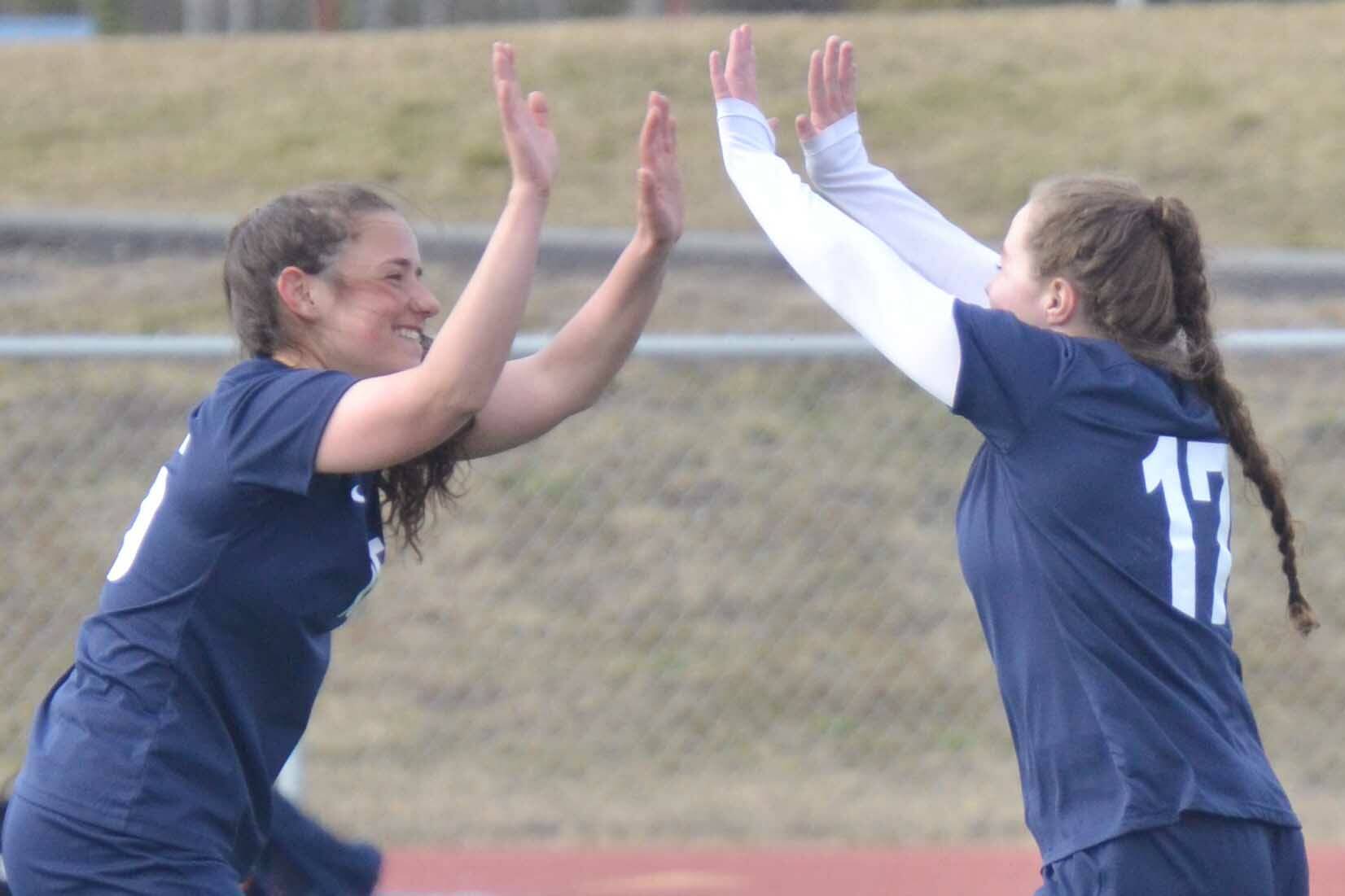 Soldotna's Katharine Bramante and Liberty Miller celebrate Miller's goal against Houston on Thursday, May 12, 2022, at Justin Maile Field at Soldotna High School in Soldotna, Alaska. (Photo by Jeff Helminiak/Peninsula Clarion)