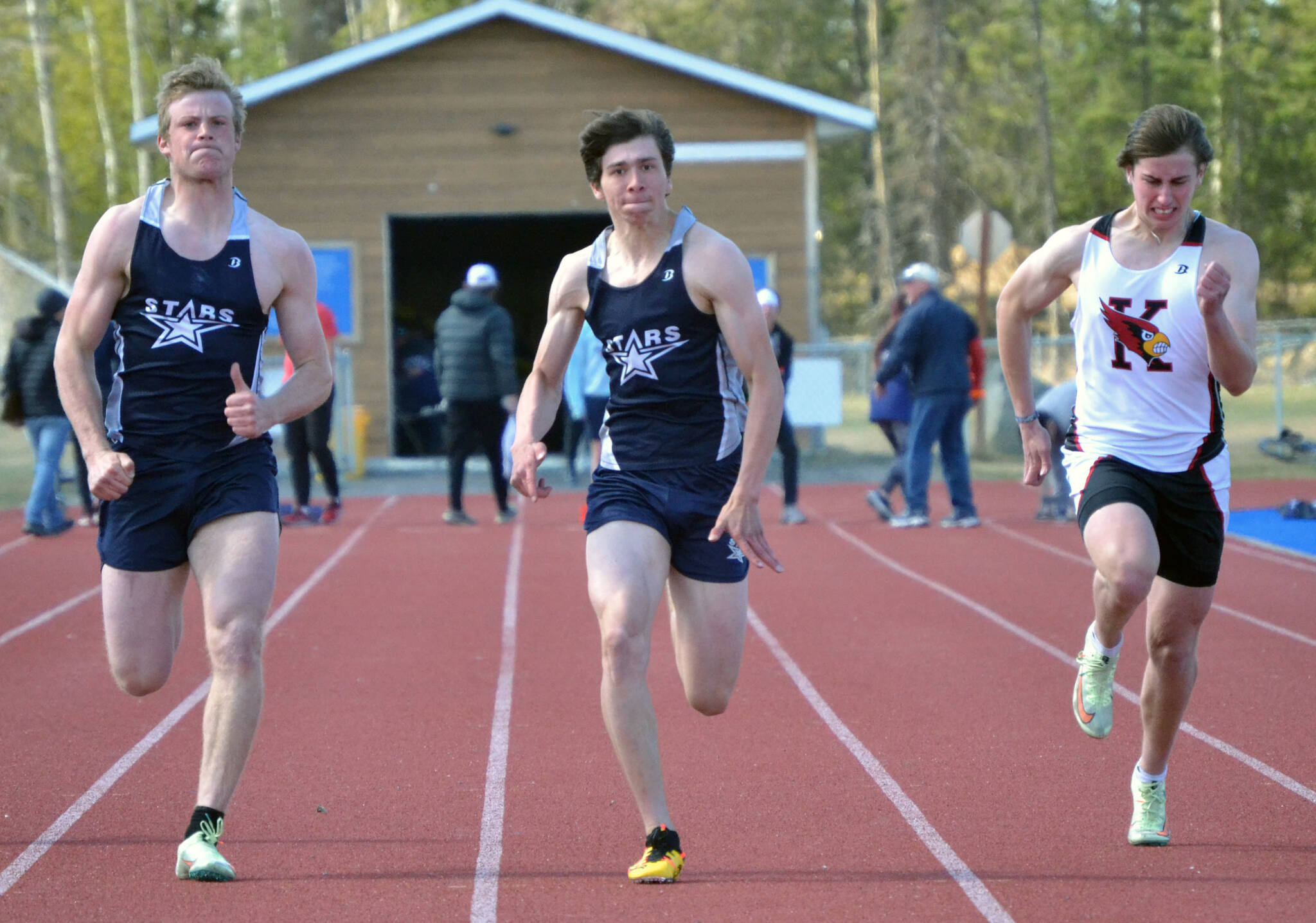 Soldotna’s Dylan Dahlgren and Leigh Tacey II, and Kenai Central’s Jacob Begich, race the 100 meters Saturday, May 14, 2022, at the Kenai Peninsula Borough Meet at Justin Maile Field at Soldotna High School in Soldotna, Alaska. Tacey II was first, Dahlgren was second and Begich was third. (Photo by Jeff Helminiak/Peninsula Clarion)