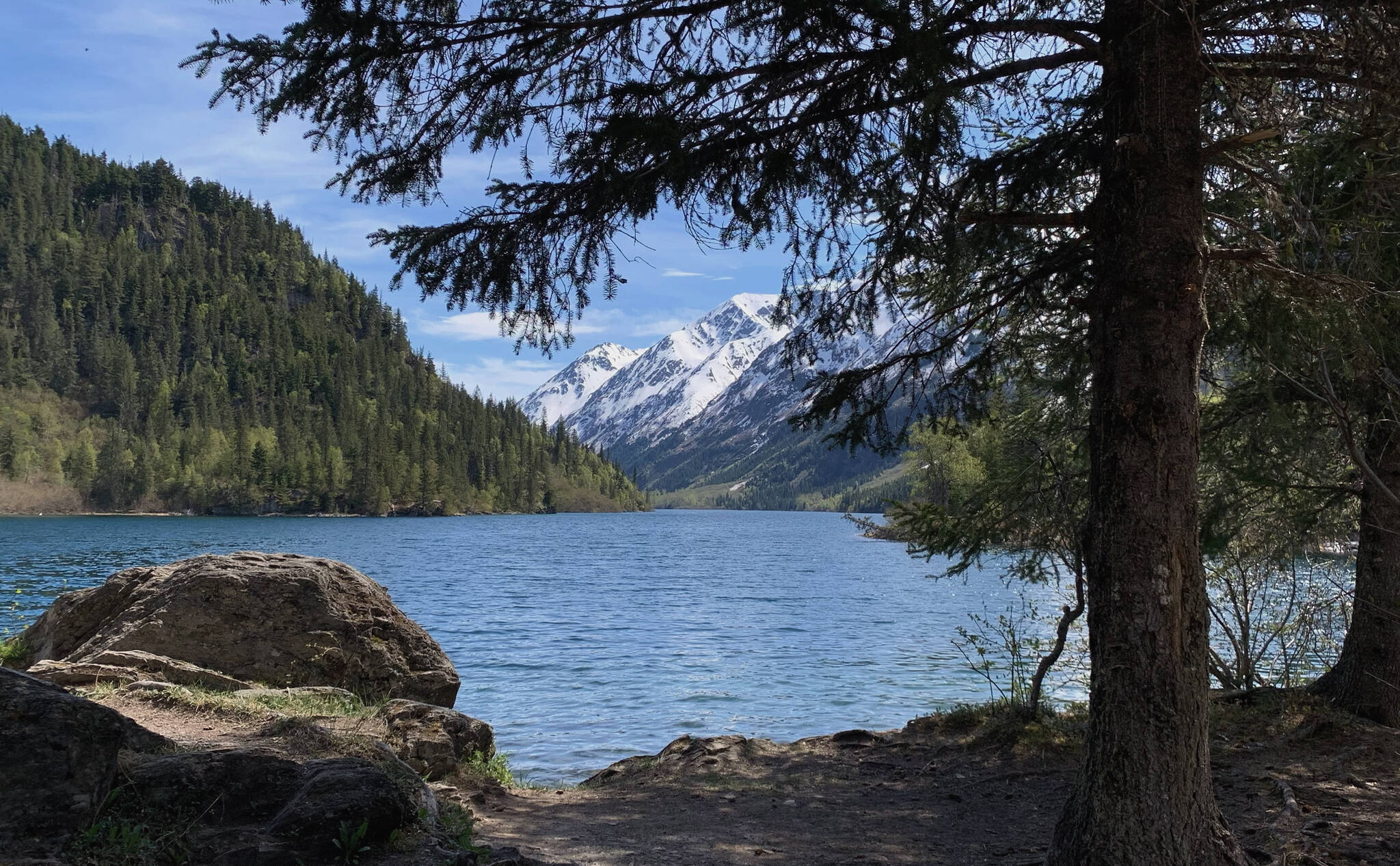 Trees and rocks frame Ptarmigan Lake on Sunday, May 22, 2022 near Seward, Alaska. (Ashlyn O’Hara/Peninsula Clarion)