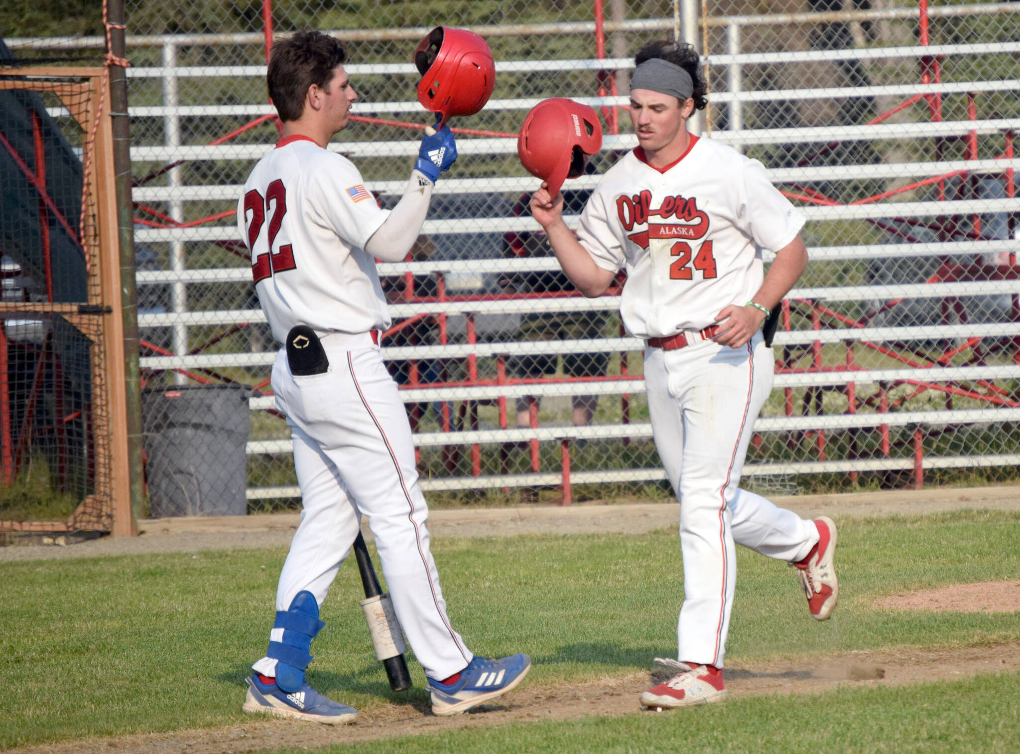 Oilers’ Noah Hennings (24) celebrates his home run against the Anchorage Glacier Pilots with Dalton Bowling on Friday, June 24, 2022, at Coral Seymour Memorial Park in Kenai, Alaska. (Photo by Jeff Helminiak/Peninsula Clarion)