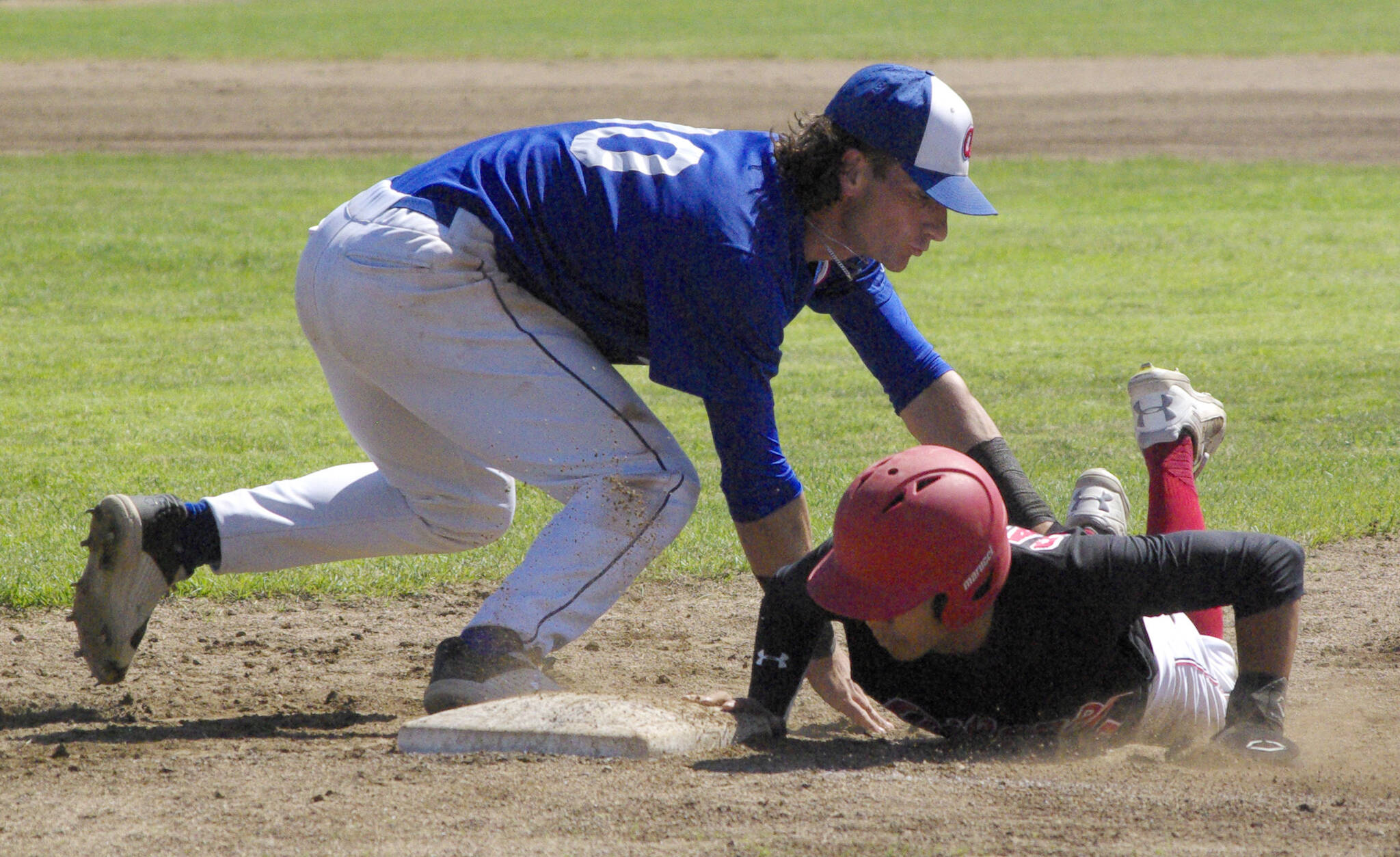 Shunsuke Sakaino of the Oilers dives under the tag of Anchorage Glacier Pilots first baseman Logan Gallina on Sunday, June 26, 2022, at Coral Seymour Memorial Park in Kenai, Alaska. (Photo by Jeff Helminiak/Peninsula Clarion)