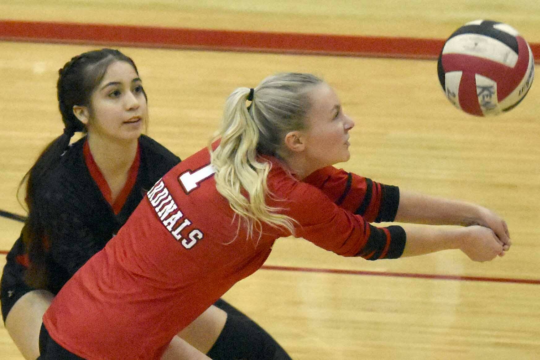 Kenai Central's Kimberly Chanley digs up a ball in front of Jaycie Castillo on Friday, Oct. 28, 2022, at Kenai Central High School in Kenai, Alaska. (Photo by Jeff Helminiak/Peninsula Clarion)