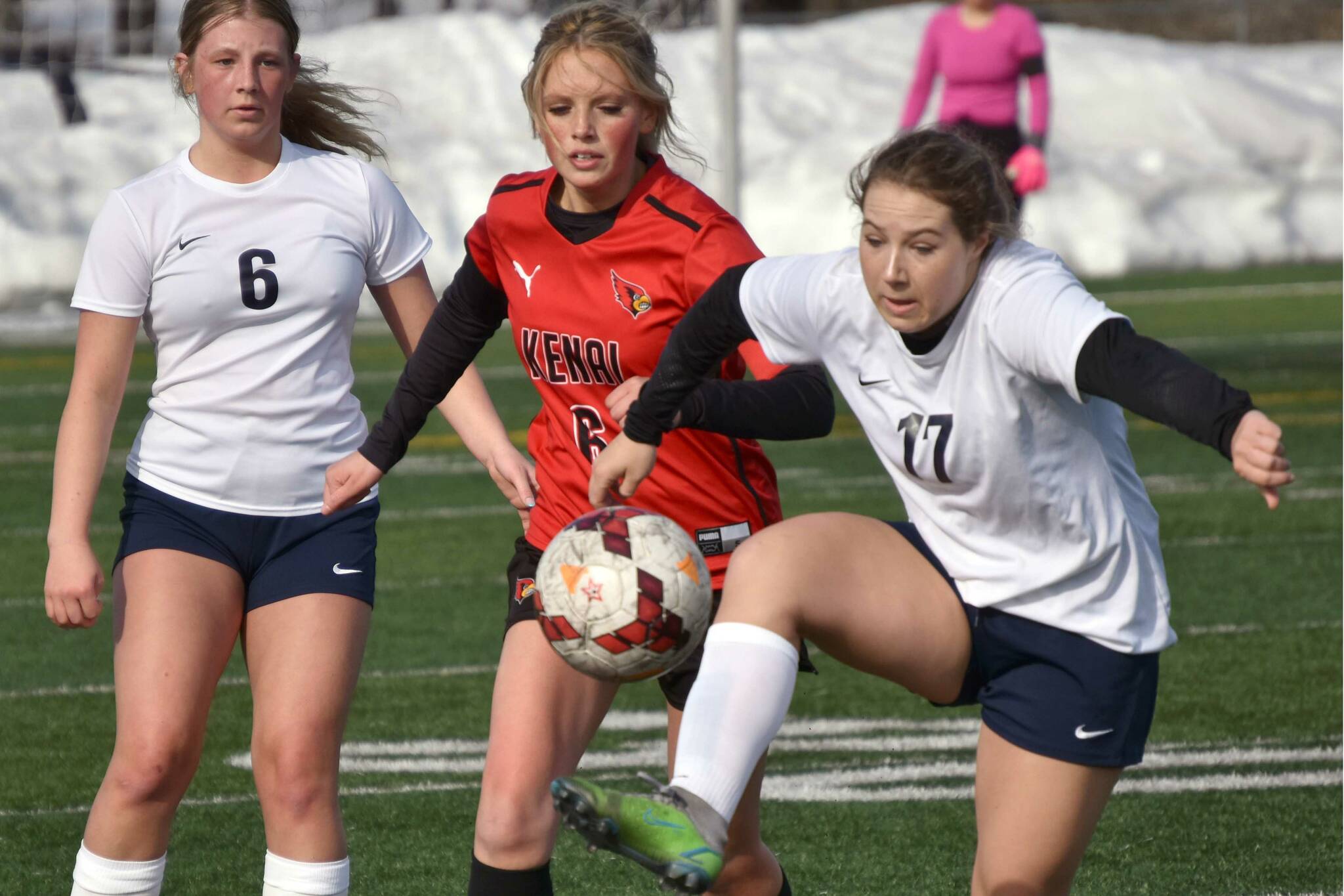 Soldotna's Liberty Miller controls the ball in front of Kenai Central's Kori Moore and Soldotna's Alex Lee on Tuesday, April 18, 2023, at Ed Hollier Field at Kenai Central High School in Kenai, Alaska. (Photo by Jeff Helminiak/Peninsula Clarion)