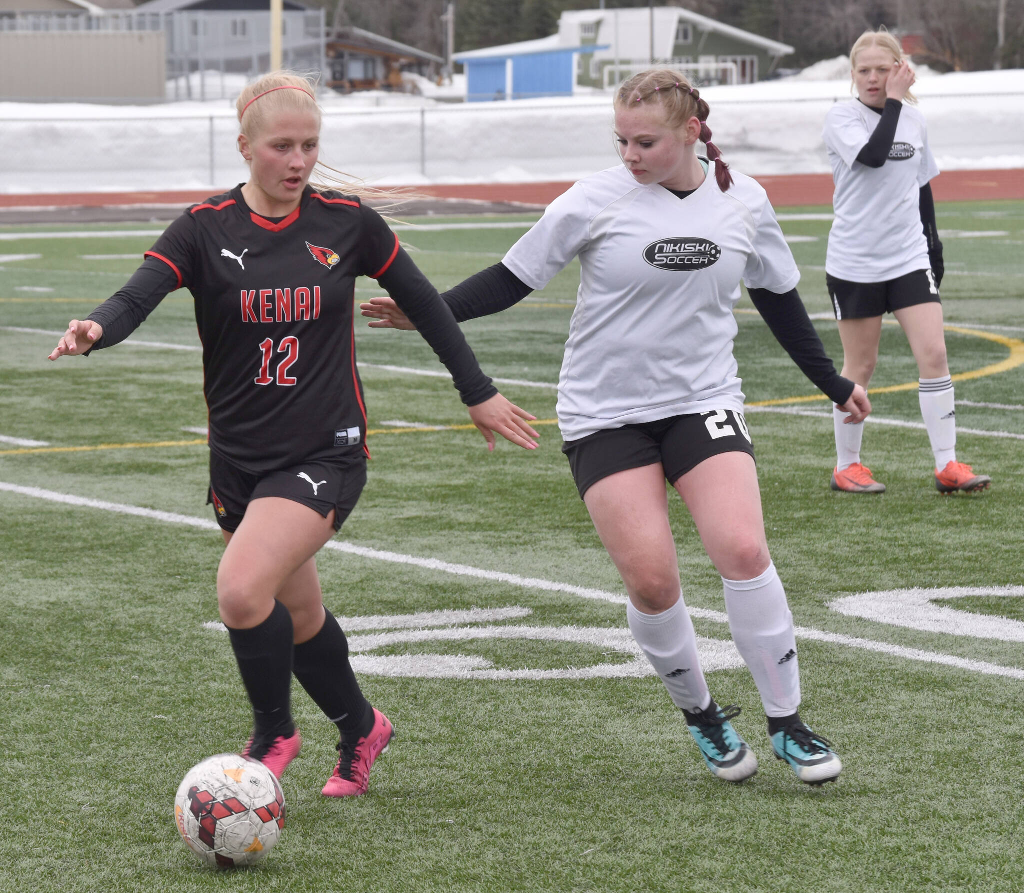 Kenai Central’s Kate Wisnewski shields the ball from Nikiski’s Wynter Yeager on Tuesday, April 25, 2023, at Ed Hollier Field at Kenai Central High School in Kenai, Alaska. (Photo by Jeff Helminiak/Peninsula Clarion)