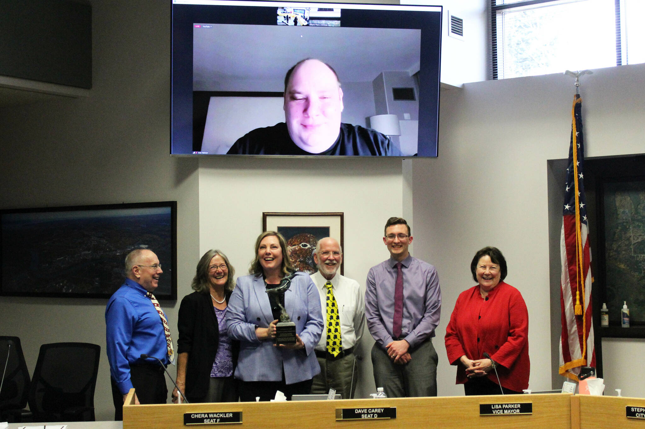 From left, Soldotna City Council Member Dave Carey, Soldotna Vice Mayor Lisa Parker, Soldotna City Manager Stephanie Queen, Soldotna Mayor Paul Whitney, and Soldotna City Council members Jordan Chilson, Linda Farnsworth-Hutchings and Dan Nelson (on screen) celebrate Queen’s contribution’s to the city during a council meeting on Wednesday, April 26, 2023 in Soldotna, Alaska. (Ashlyn O’Hara/Peninsula Clarion)