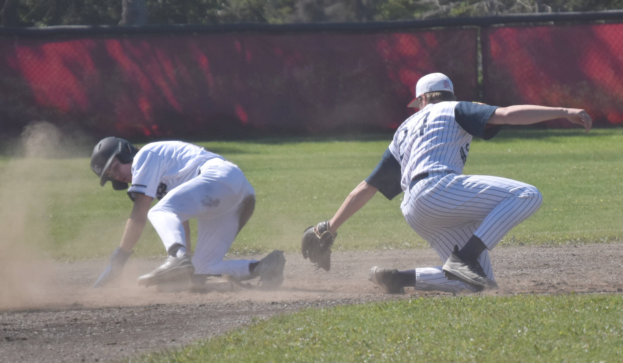 Easton Marshall of Lower Columbia (Washington) Baseball Club slides past Legion Twins second baseman Andrew Pieh on Saturday, July 1, 2023, at the Kenai Little League fields. (Photo by Jeff Helminiak/Peninsula Clarion)