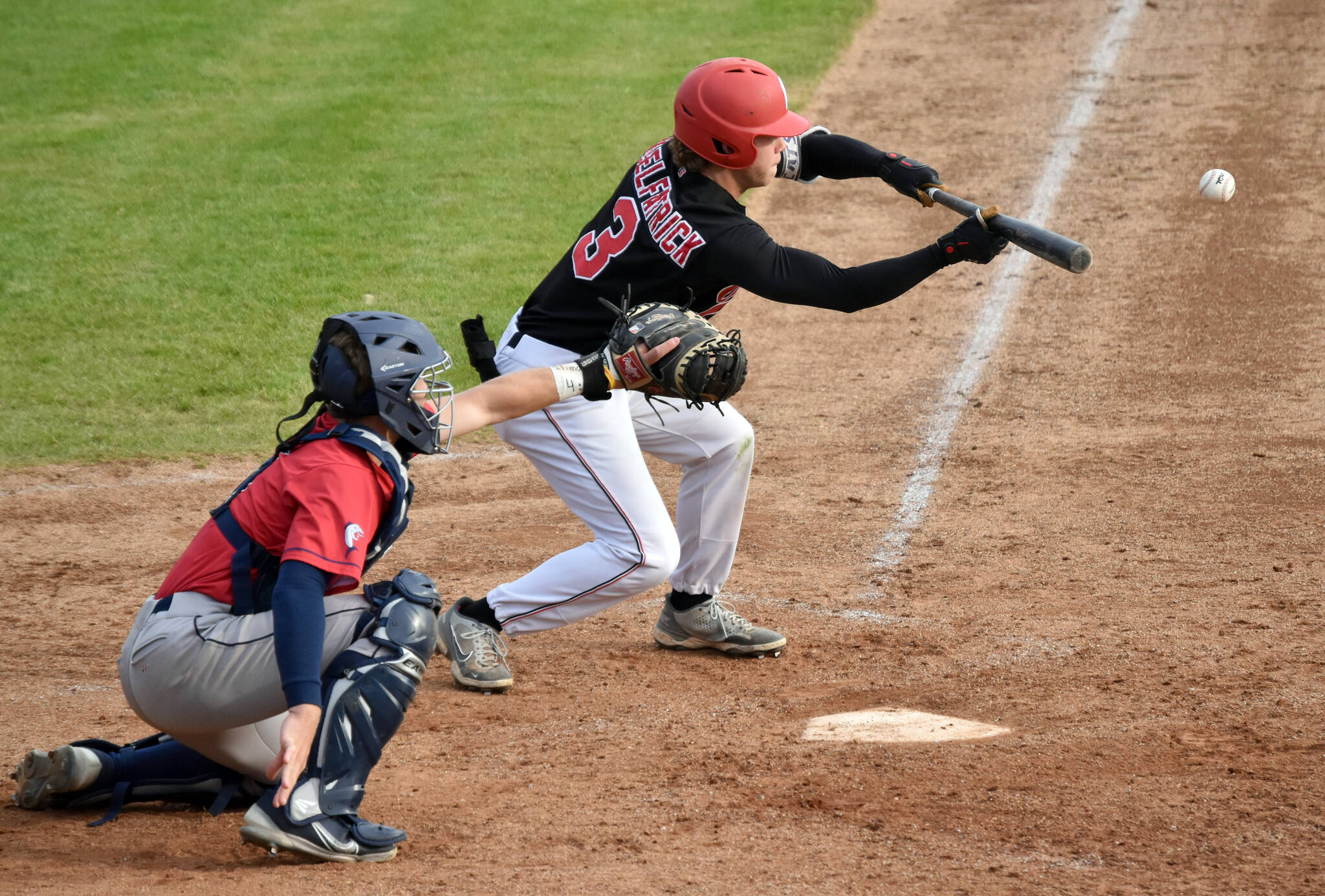 Owen McElfatrick of the Peninsula Oilers bunts for a base hit against the Chugiak-Eagle River Chinooks on Thursday, July 27, 2023, at Coral Seymour Memorial Park in Kenai, Alaska. (Photo by Jeff Helminiak/Peninsula Clarion)