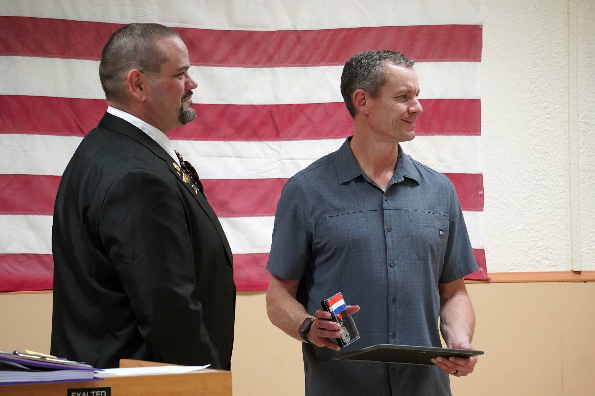 Kenai Elks Lodge Exalted Ruler Allen Burkett presents Kenai Fire Marshal Jeremy Hamilton with an award at the Kenai Elks Lodge in Kenai, Alaska, on Friday, Oct. 6, 2023. (Jake Dye/Peninsula Clarion)