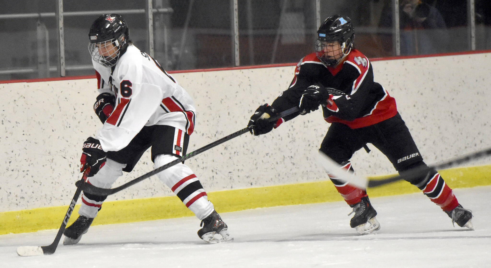 Kenai Central’s Braden Smith shields the puck from Houston’s Brayden Spain on Thursday, Oct. 26, 2023, at the Kenai Multi-Purpose Facility in Kenai, Alaska. (Photo by Jeff Helminiak/Peninsula Clarion)