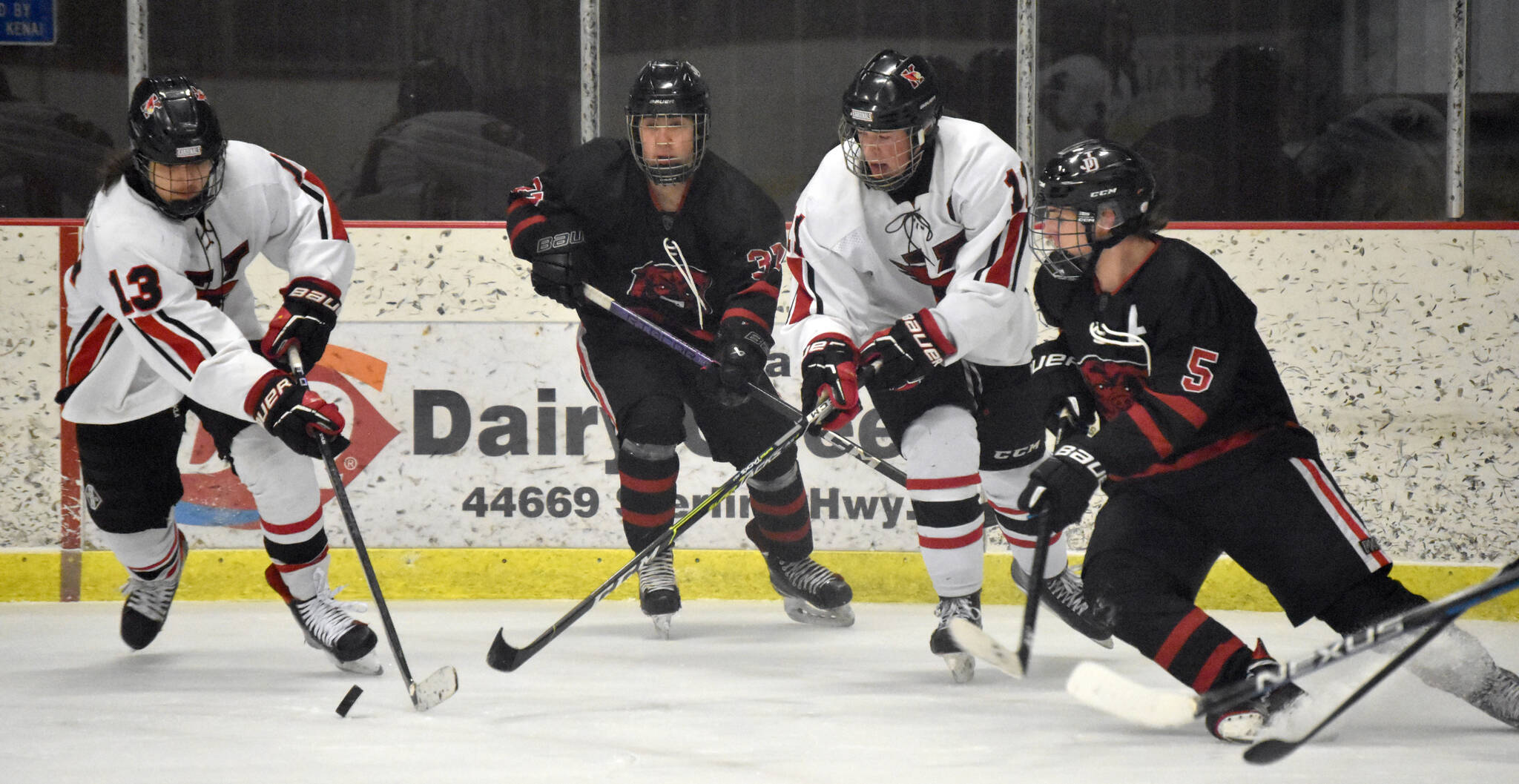 Kenai Central’s William Howard emerges from the crowd with the puck Friday, Jan. 19, 2024, at the Kenai Multi-Purpose Facility in Kenai, Alaska. (Photo by Jeff Helminiak/Peninsula Clarion)