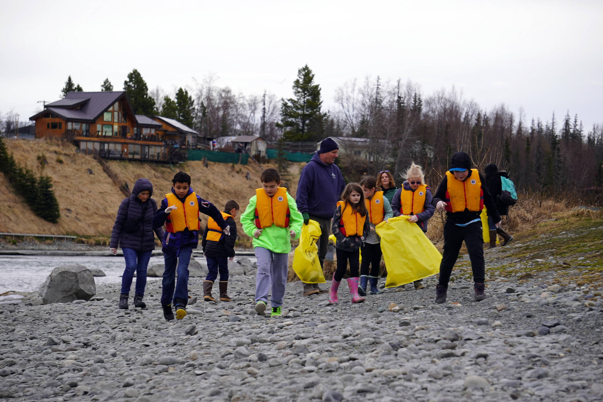 Students of Soldotna Montessori Charter School comb for trash along the banks of the Kenai River at Centennial Park in Soldotna, Alaska, on Thursday, May 2, 2024. (Jake Dye/Peninsula Clarion)