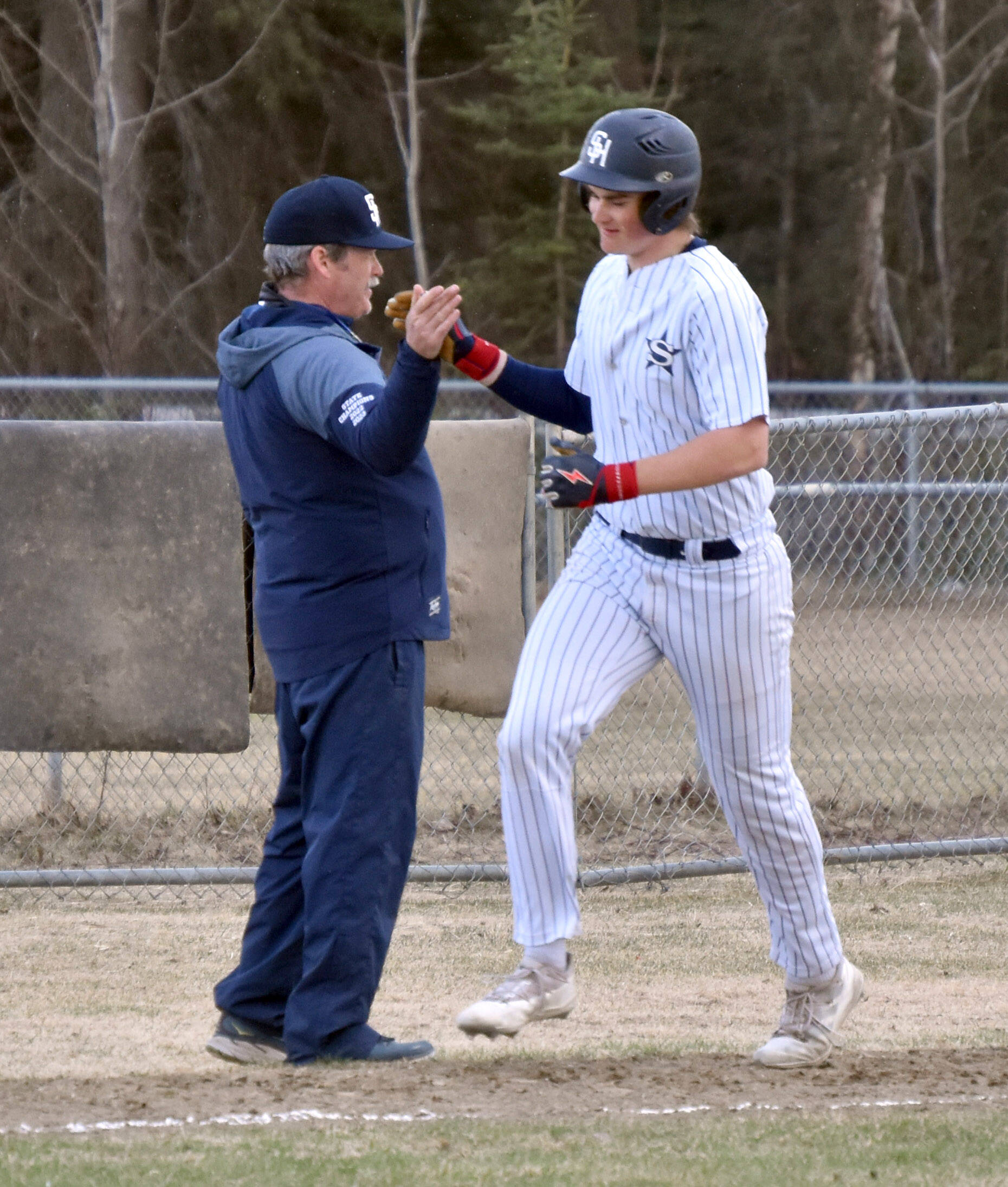 Soldotna head coach Ken Gibson congratulates Wyatt Gagnon after his two-run home run Tuesday, May 7, 2024, at the Soldotna Little League fields in Soldotna, Alaska. (Photo by Jeff Helminiak/Peninsula Clarion)