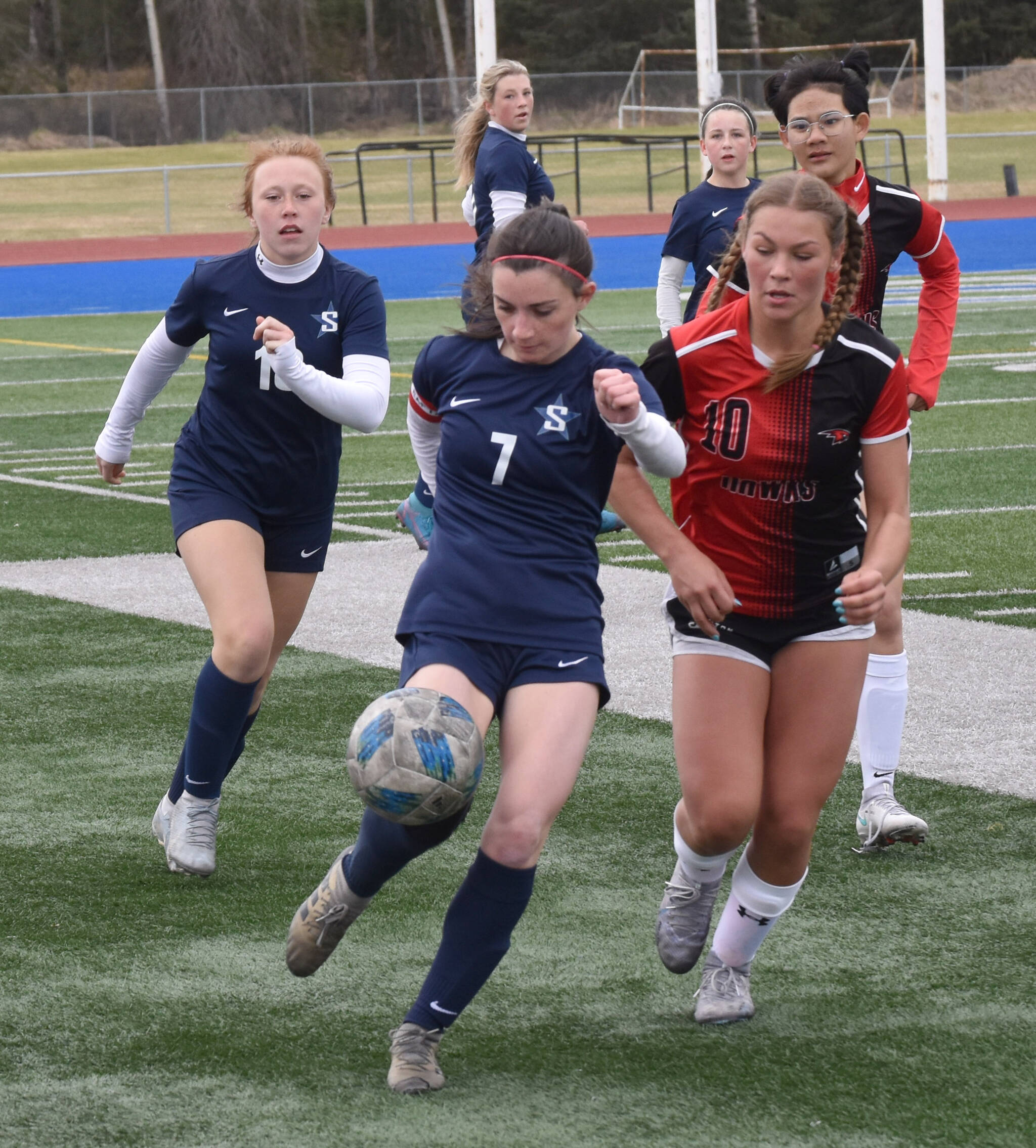 Soldotna’s Bay Bloom kicks the ball in front of Houston’s Bella Russell on Friday, May 10, 2024, at Soldotna High School in Soldotna, Alaska. (Photo by Jeff Helminiak/Peninsula Clarion)