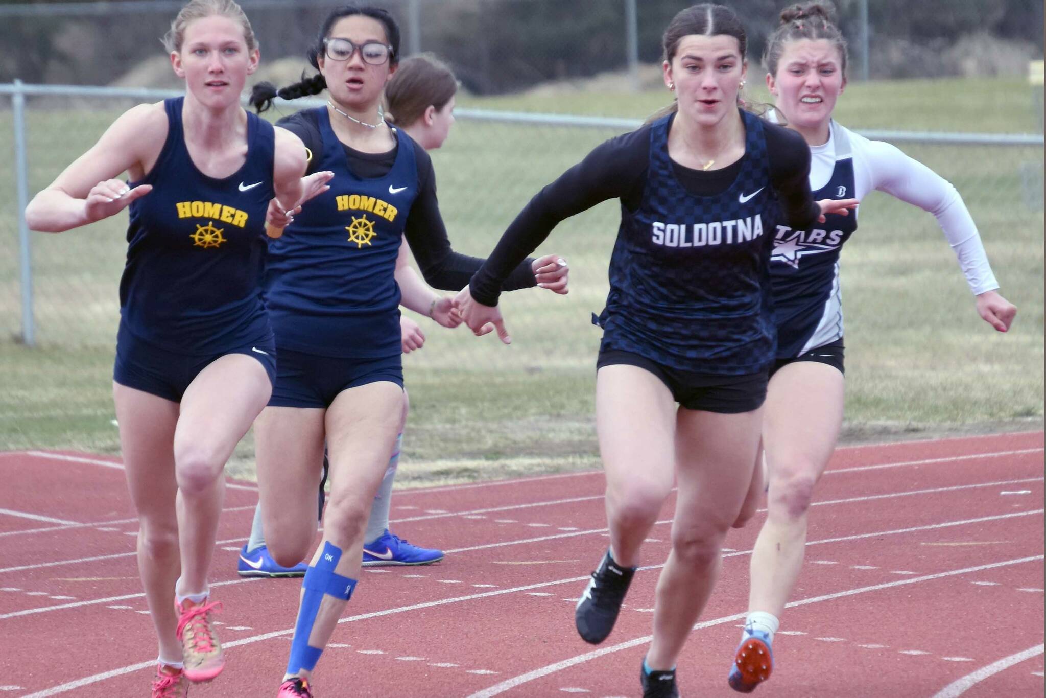 Homer's Immy Im hands off to Gracie Miotke, and Soldotna's Mia Hannevold hands off to Anaulie Sedivy, at the 400-meter relay Saturday, May 11, 2024, at the Kenai Peninsula Borough meet at Soldotna High School in Soldotna, Alaska. Homer won the relay. (Photo by Jeff Helminiak/Peninsula Clarion)