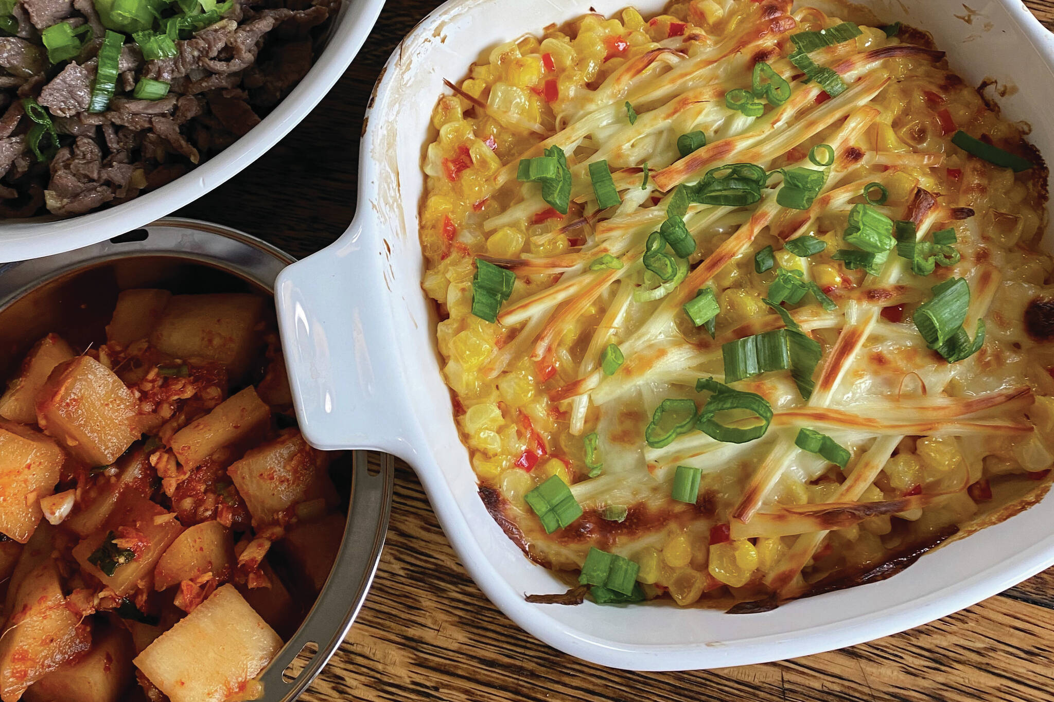 Corn cheese is served alongside grilled beef, kimchi and lettuce. (Photo by Tressa Dale/Peninsula Clarion)