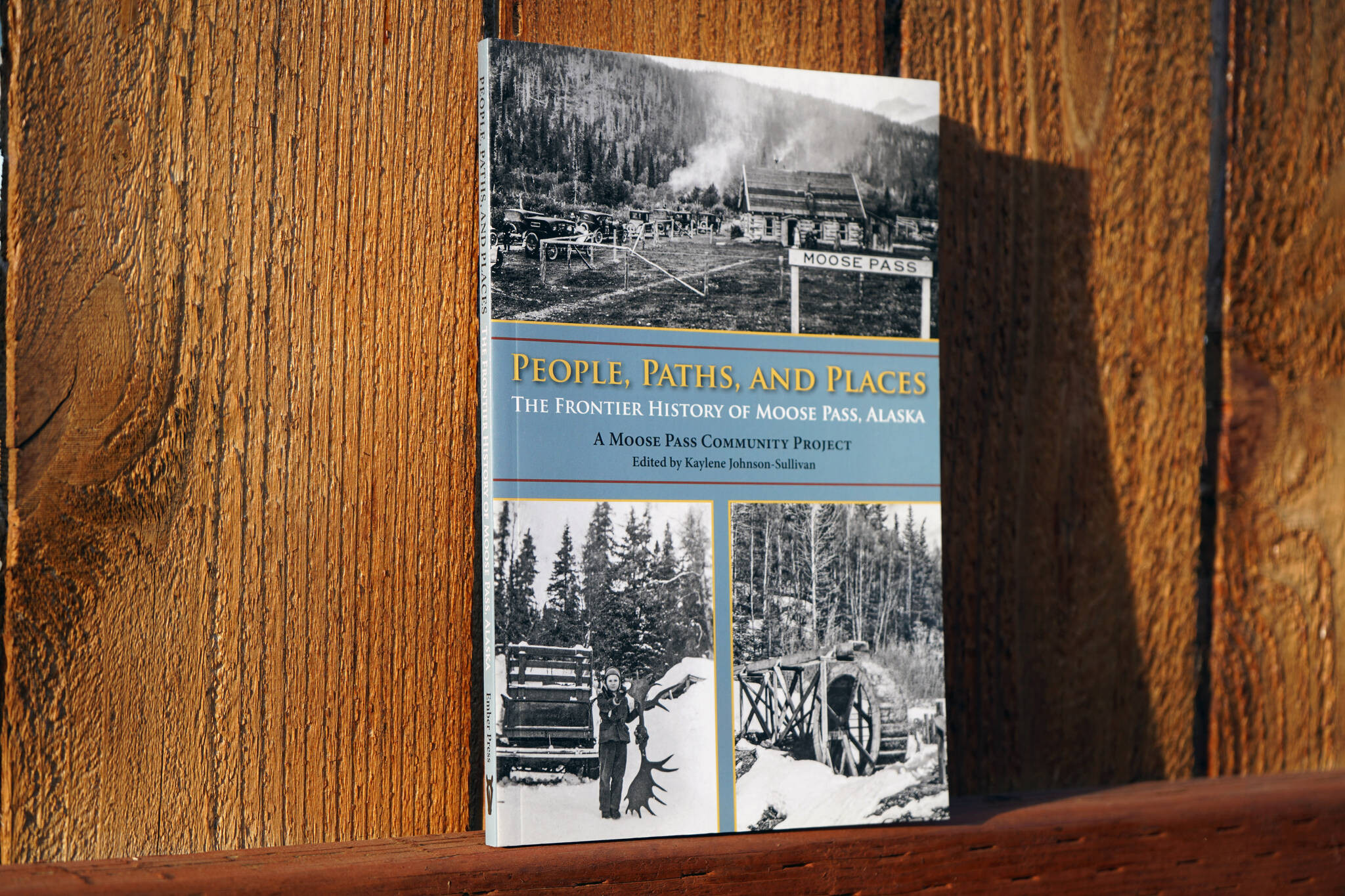 A copy of “People, Paths, and Places: The Frontier History of Moose Pass, Alaska” stands in sunlight in Soldotna, Alaska, on Friday, Sept. 29, 2023. (Jake Dye/Peninsula Clarion)