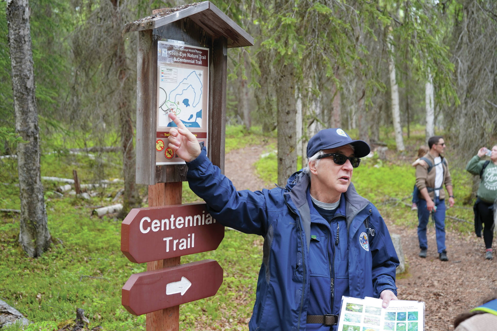 A guide from the Kenai National Wildlife Refuge leads visitors on a hike of Centennial Trail near Soldotna on Saturday, June 1, 2024. (Jake Dye/Peninsula Clarion)