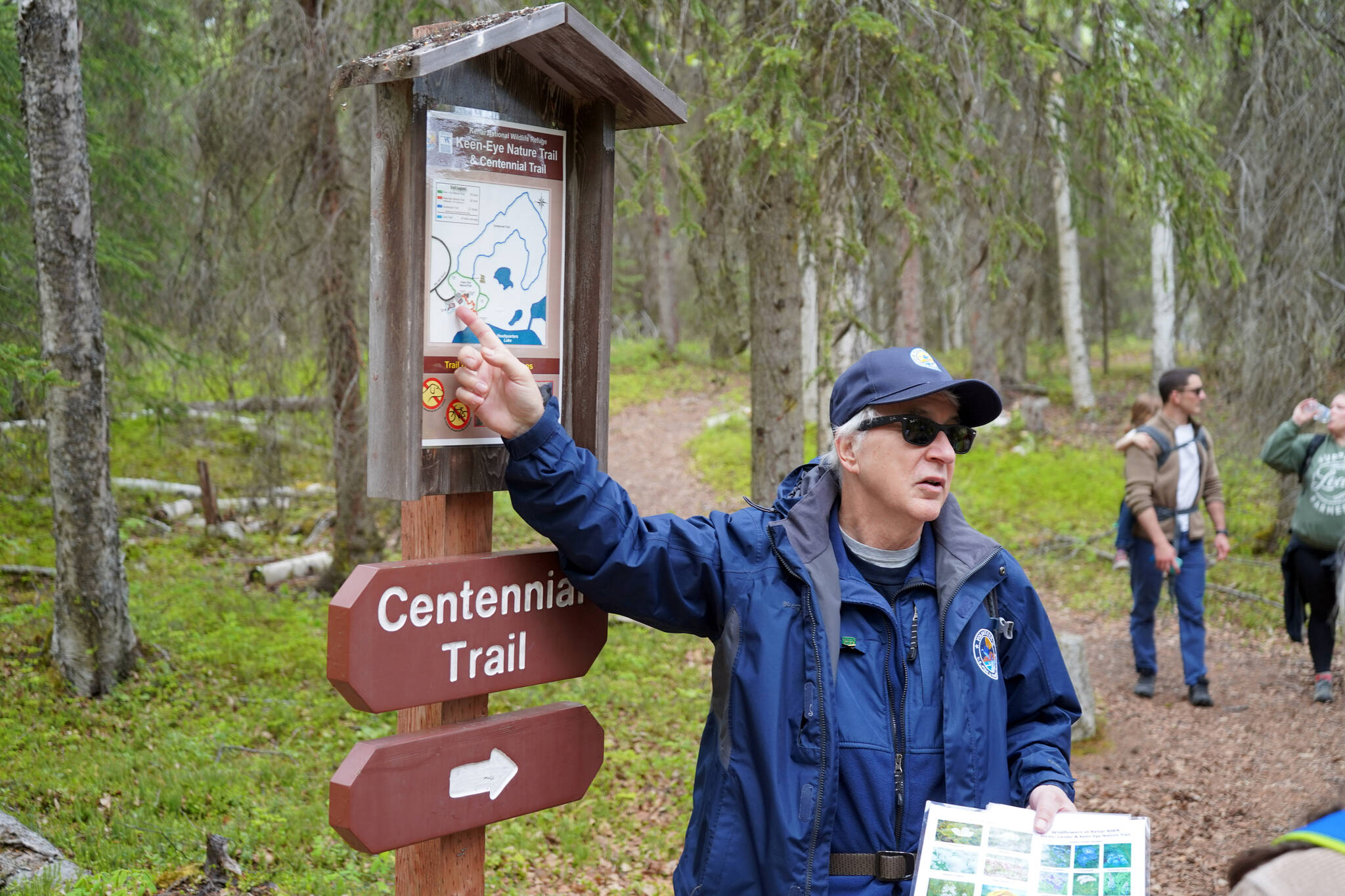 A guide from the Kenai National Wildlife Refuge leads visitors on a hike of Centennial Trail near Soldotna, Alaska, on Saturday, June 1, 2024. (Jake Dye/Peninsula Clarion)