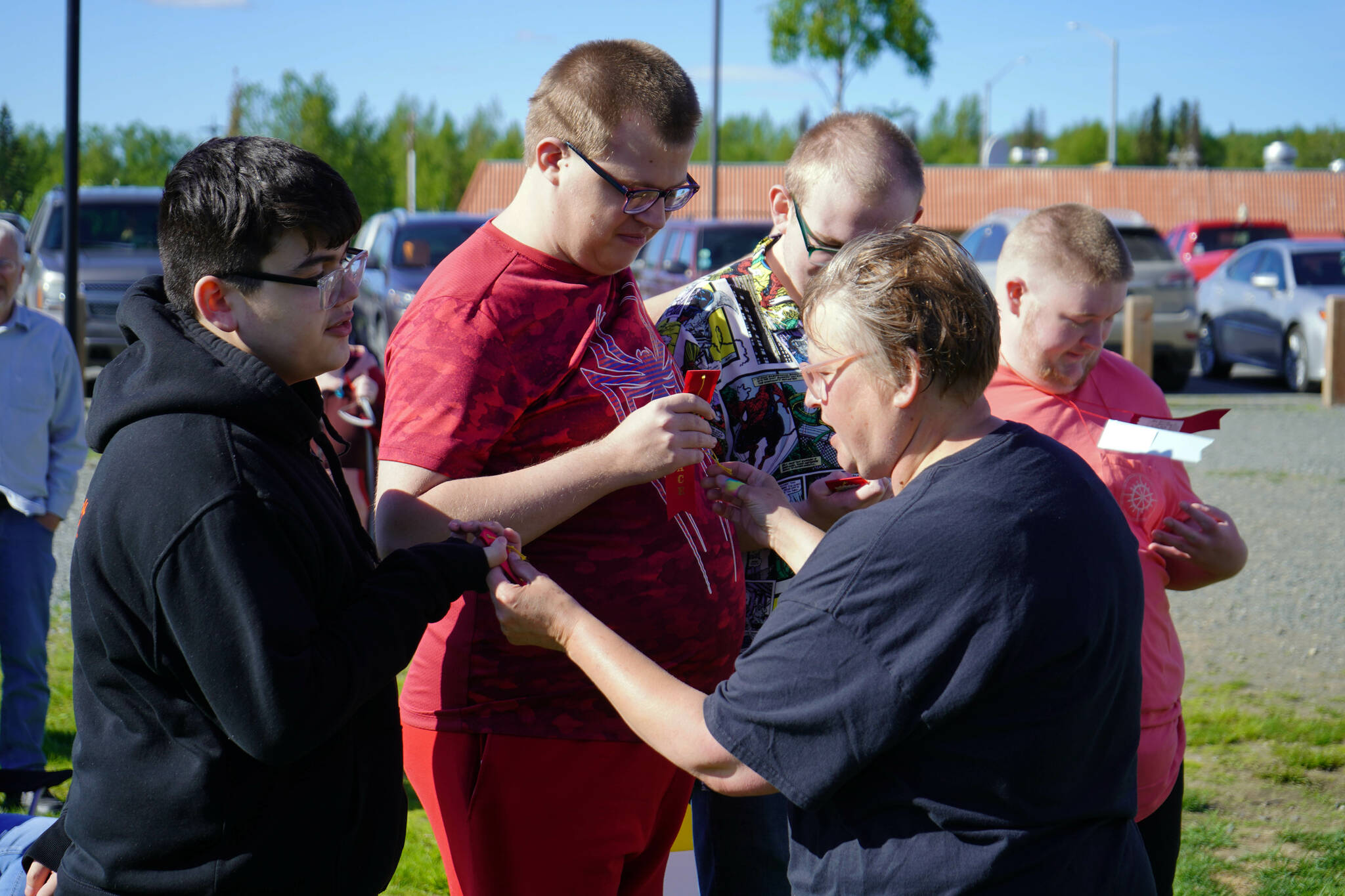 Coach Heidi Renner awards athletes from the Central Kenai Peninsula’s Special Olympics Alaska swim team with ribbons they earned in recent competition at Soldotna Creek Park in Soldotna, Alaska, on Tuesday, June 4, 2024. (Jake Dye/Peninsula Clarion)