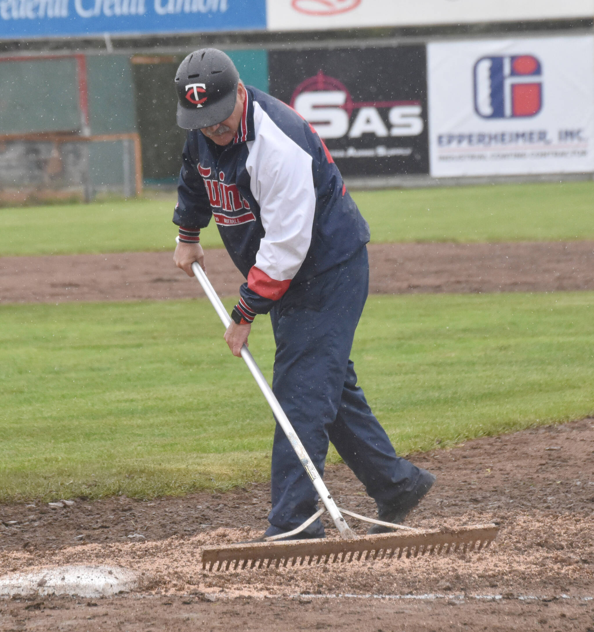 American Legion Post 20 Twins assistant coach Ken Gibson works the diamond between innings of a game against Eagle River on Wednesday, June 5, 2024, at Coral Seymour Memorial Park in Kenai, Alaska. (Photo by Jeff Helminiak/Peninsula Clarion)