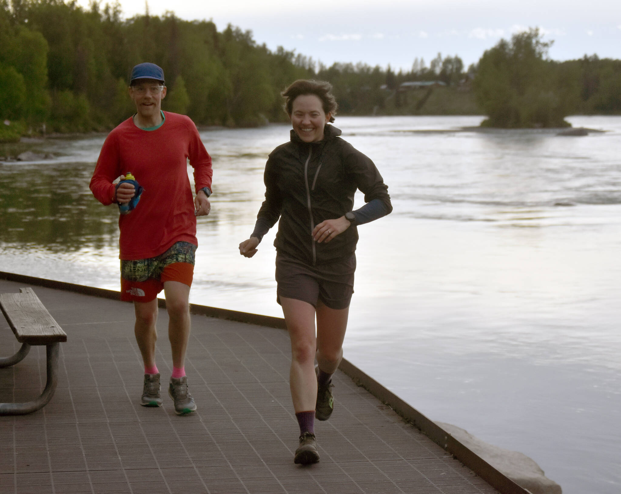 Girdwood’s Zach Behney and Anchorage’s Julianne Dickerson run along the Kenai River at the Tsalteshi Backyard Ultra on Friday, June 8, 2024, in Soldotna, Alaska. (Photo by Jeff Helminiak/Peninsula Clarion)