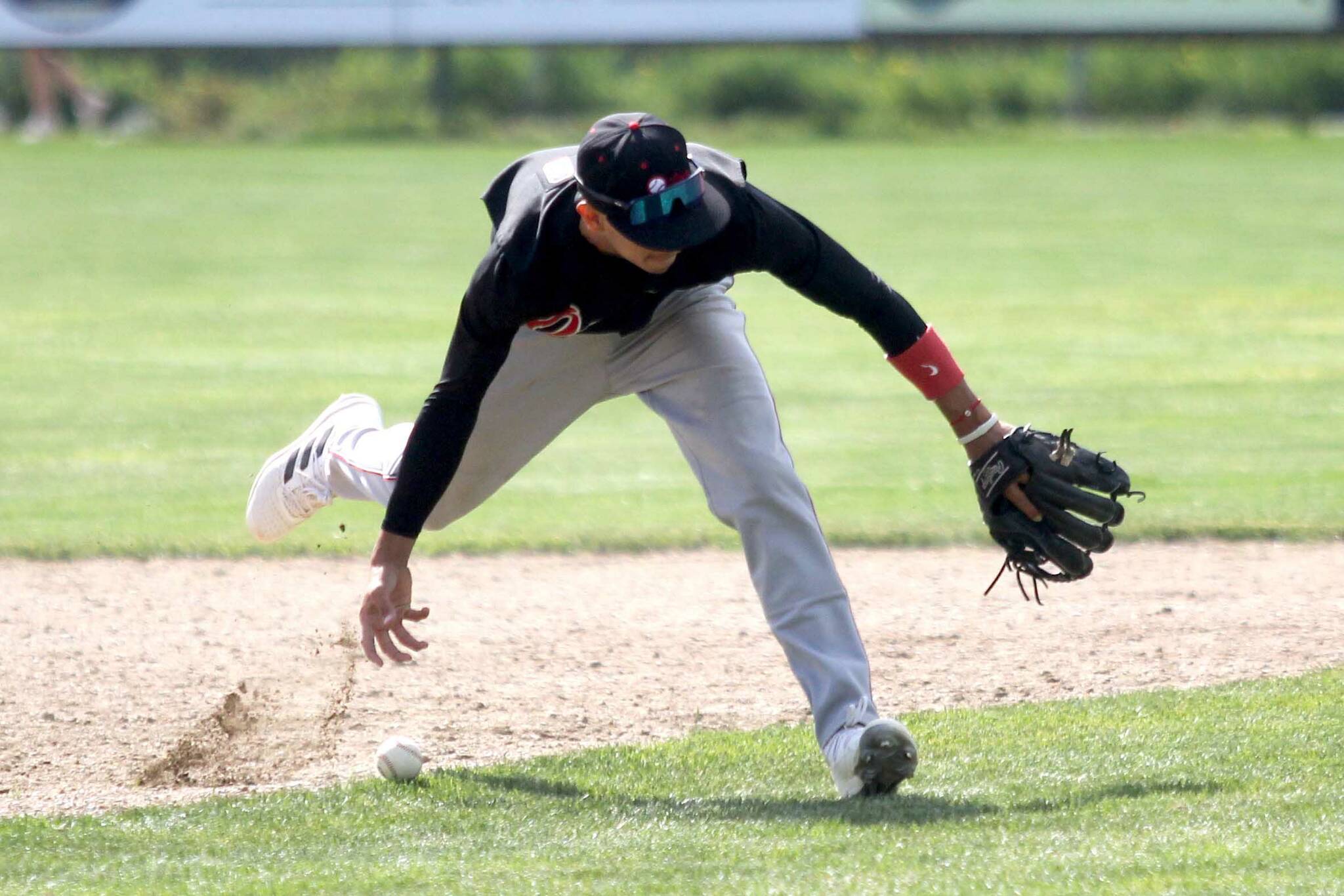 Oilers shortstop Petey Soto tries to bare-hand a ground ball during a 9-2 loss to the Mat-Su Miners on Sunday, June 9, 2024, at Hermon Brothers Field in Palmer, Alaska. (Photo by Jeremiah Bartz/Frontiersman)