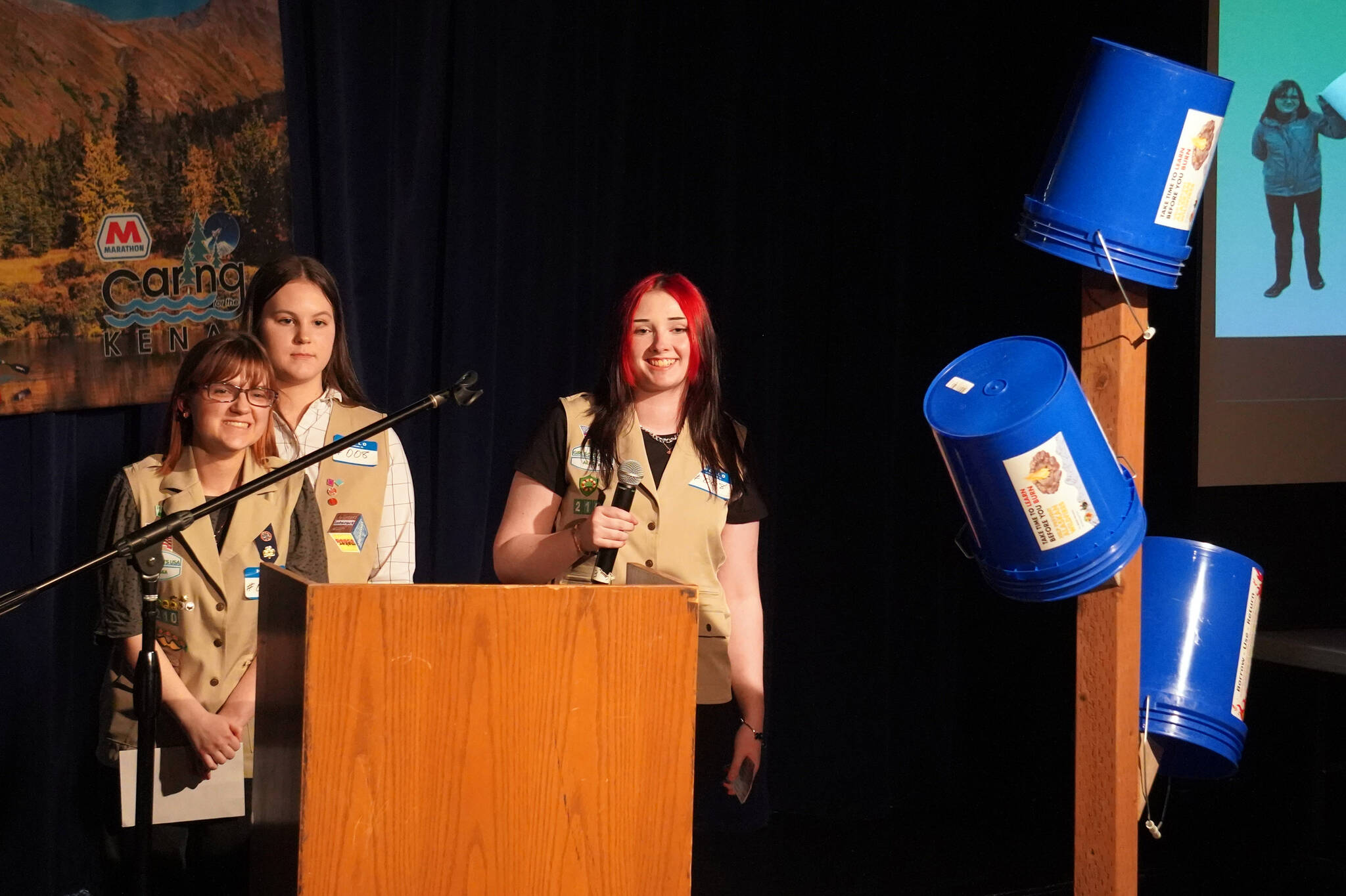 Girl Scout Troop 210, which includes Caitlyn Eskelin, Emma Hindman, Kadie Newkirk and Lyberty Stockman, present their "Bucket Trees" to a panel of judges in the 34th Annual Caring for the Kenai Competition at Kenai Central High School in Kenai, Alaska, on Thursday, April 18, 2024. (Jake Dye/Peninsula Clarion)