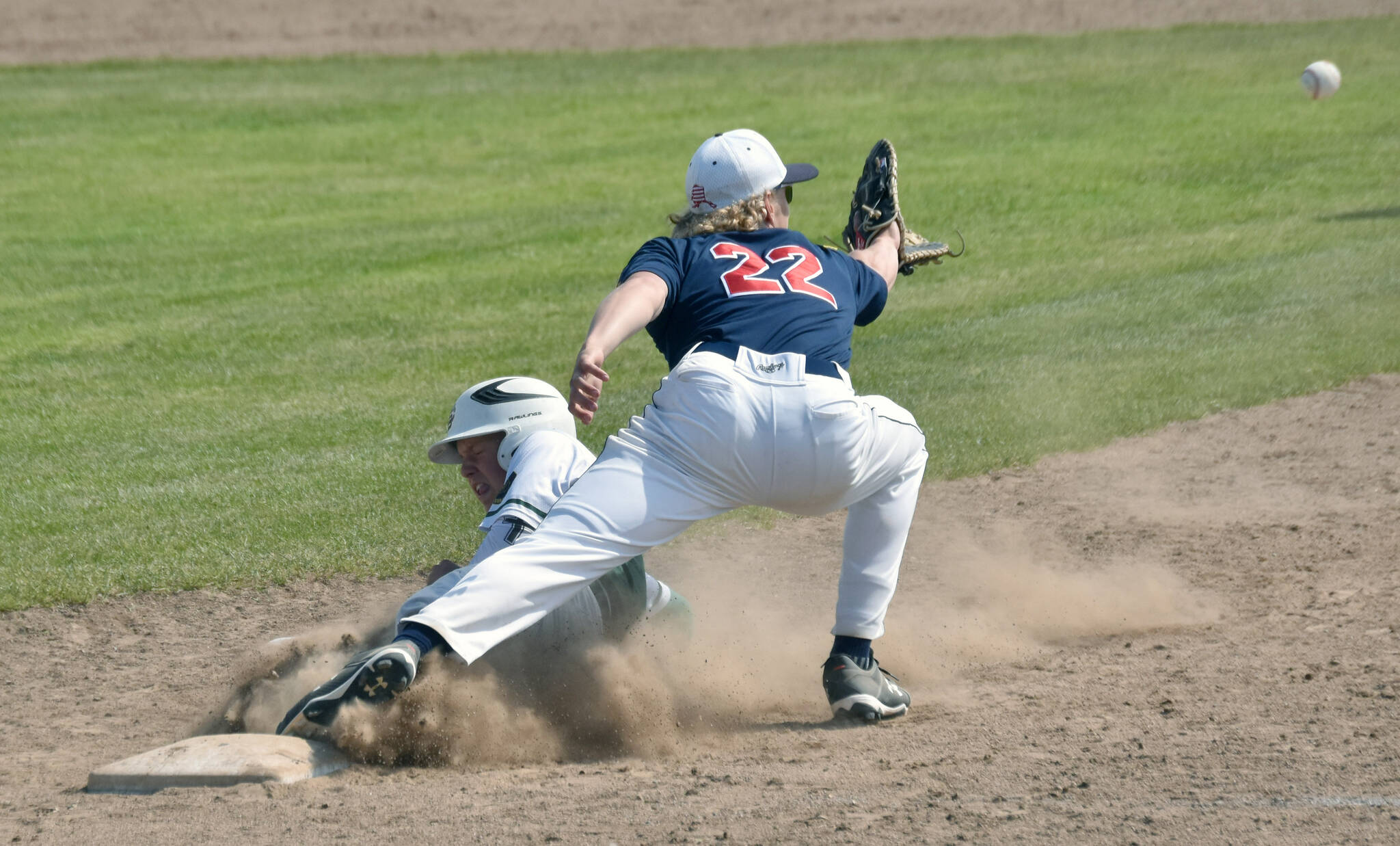 Service’s Landon Martindale gets back to first base safely in front of Post 20 Twins first baseman Matthew Schilling on Sunday, June 23, 2024, at Coral Seymour Memorial Park in Kenai, Alaska. (Photo by Jeff Helminiak/Peninsula Clarion)