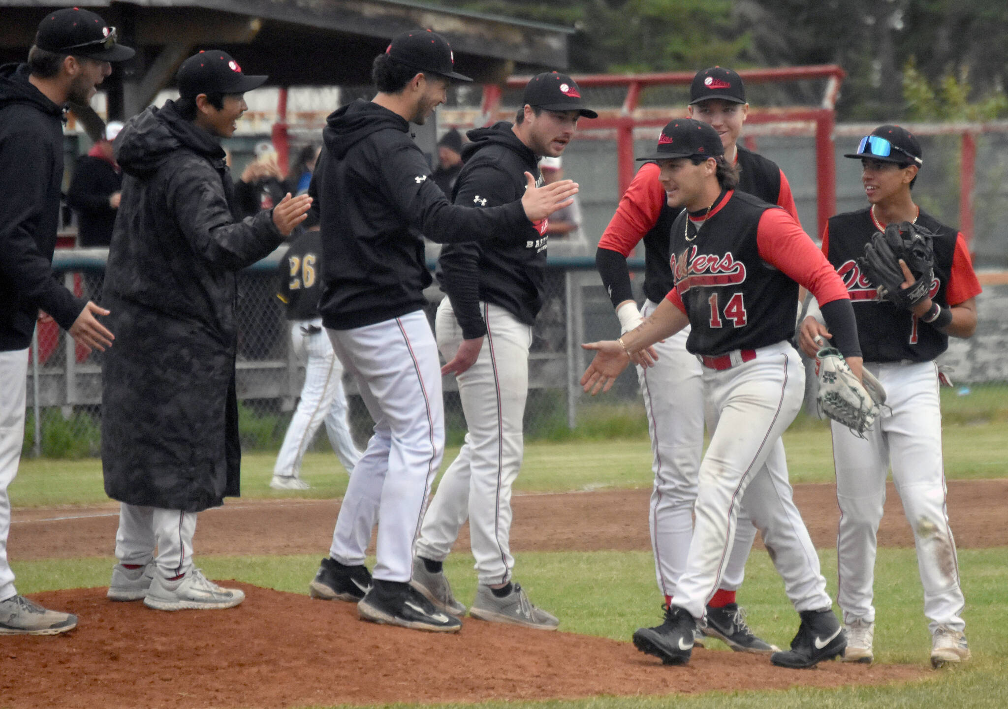 The Peninsula Oilers congratulate left fielder Elijah Vogelsong-Lewis for throwing out the tying run at the plate to end the game with the Anchorage Bucs on Saturday, June 29, 2024, at Coral Seymour Memorial Park in Kenai, Alaska. (Photo by Jeff Helminiak/Peninsula Clarion)