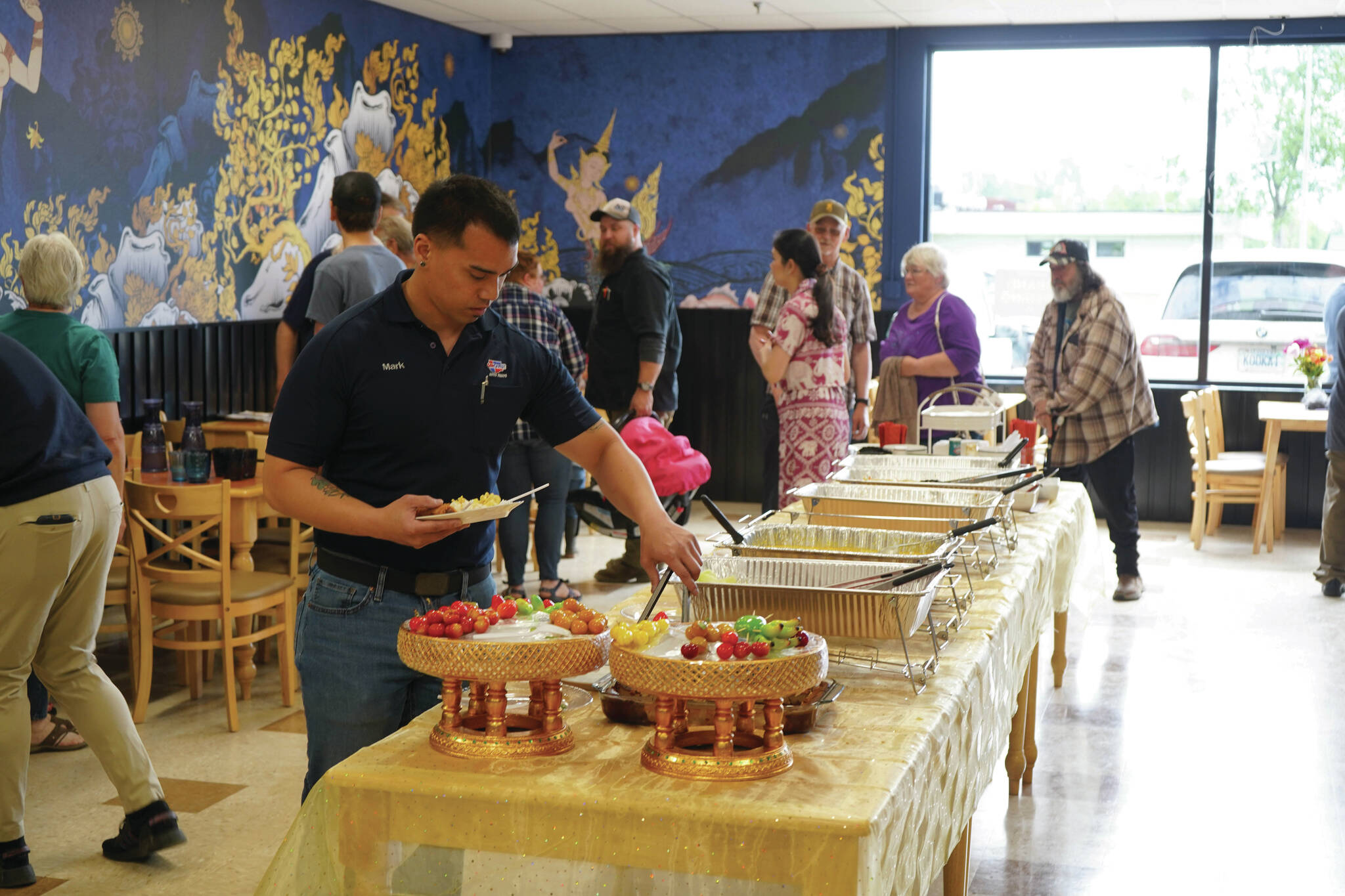 Jake Dye/Peninsula Clarion
Attendees take food from a buffet during the grand opening of Siam Noodles and Food in Kenai on Tuesday.