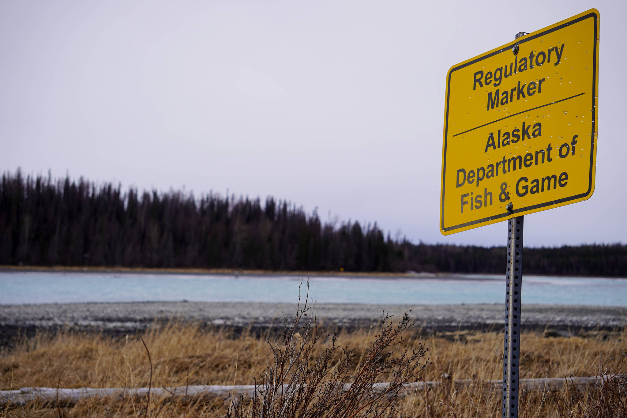 An Alaska Department of Fish and Game regulatory marker is seen at the outlet of Skilak Lake near Cooper Landing, Alaska, on Saturday, March 23, 2024. (Jake Dye/Peninsula Clarion)