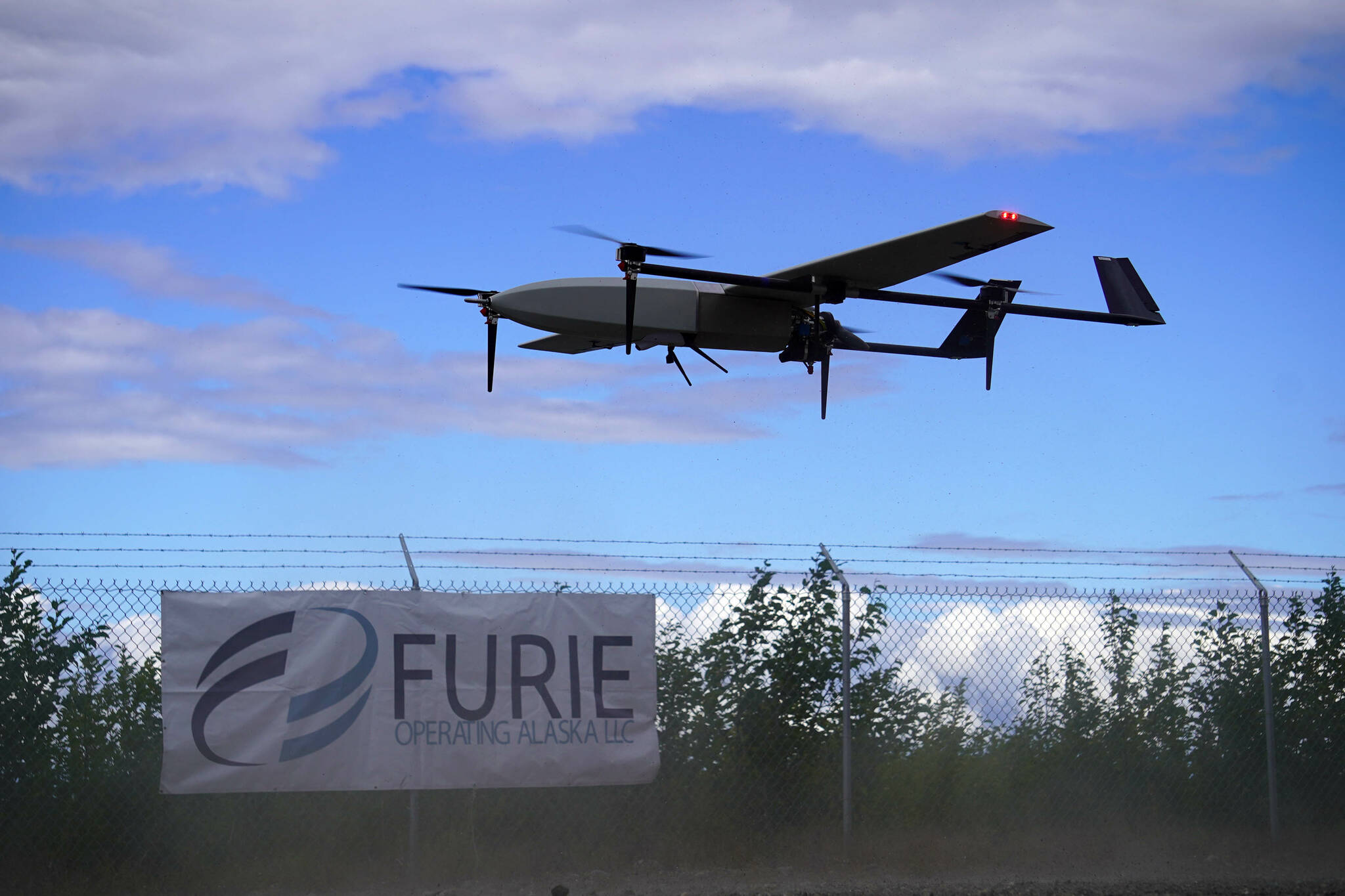 A drone rises into the air while kicking up dust, departing on a test flight for the use of beyond visual line of sight drone aircraft, at Furie Operating Alaska’s central processing facility in Nikiski, Alaska, on Wednesday, July 10, 2024. (Jake Dye/Peninsula Clarion)