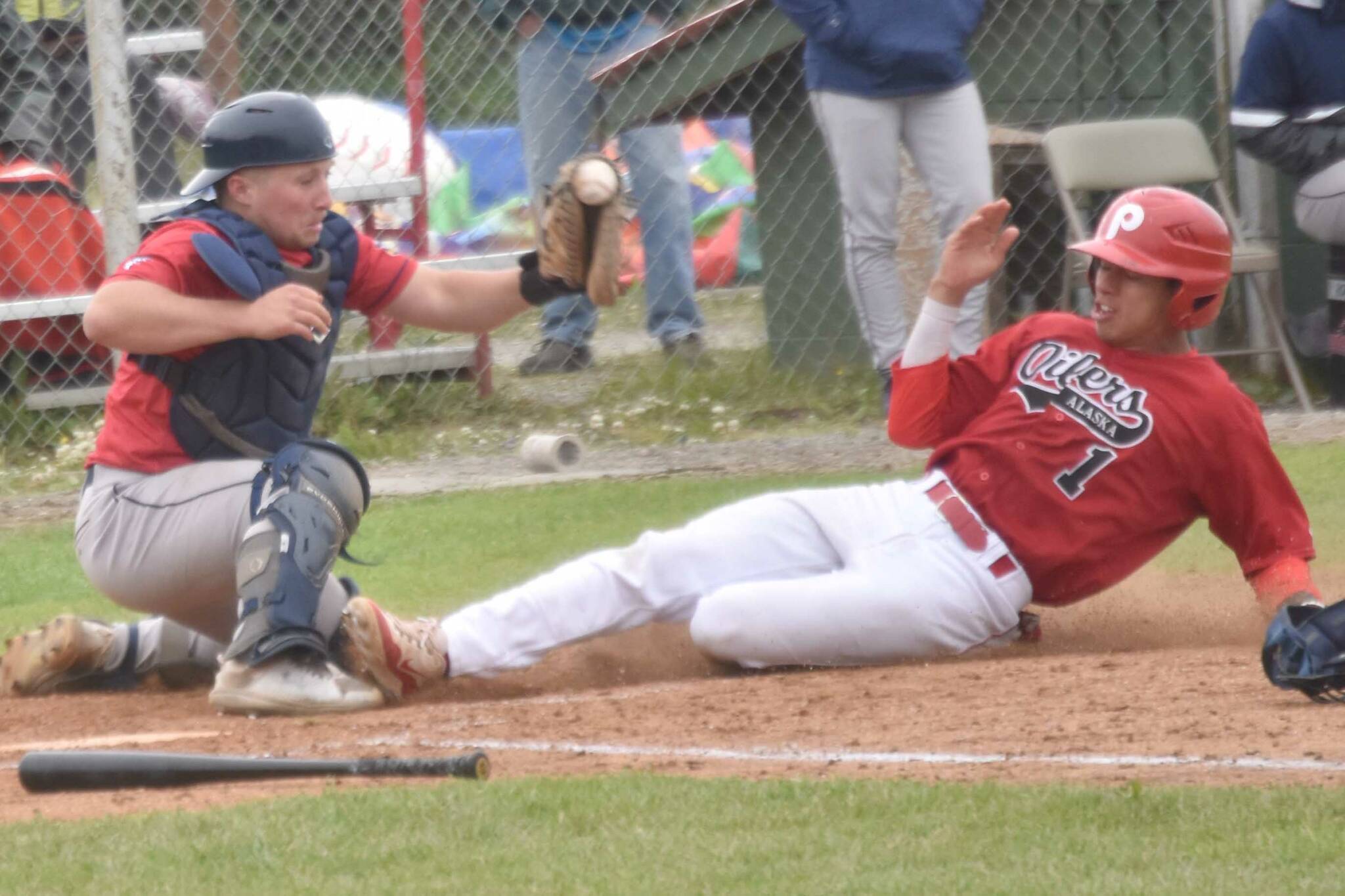 Chugiak-Eagle River Chinooks catcher Dustin Isanogle tags out Petey Soto of the Peninsula Oilers at home during the second game of a doubleheader Sunday, July 14, 2024, at Coral Seymour Memorial Park in Kenai, Alaska. (Photo by Jeff Helminiak/Peninsula Clarion)