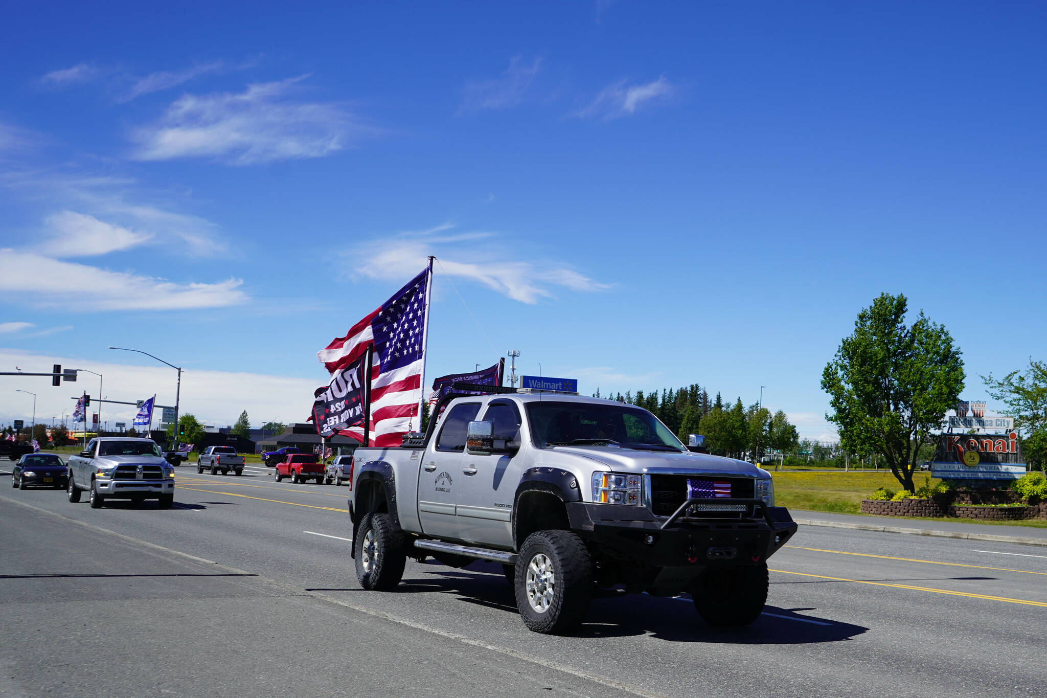 A parade of cars and trucks flying flags in support of former President Donald Trump proceed down the Kenai Spur Highway in Kenai, Alaska, on Sunday, July 14, 2024. (Jake Dye/Peninsula Clarion)