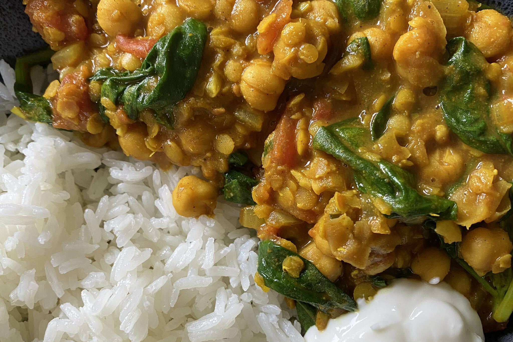 Chickpea lentil and spinach curry is served with rice and yogurt. (Photo by Tressa Dale/Peninsula Clarion)