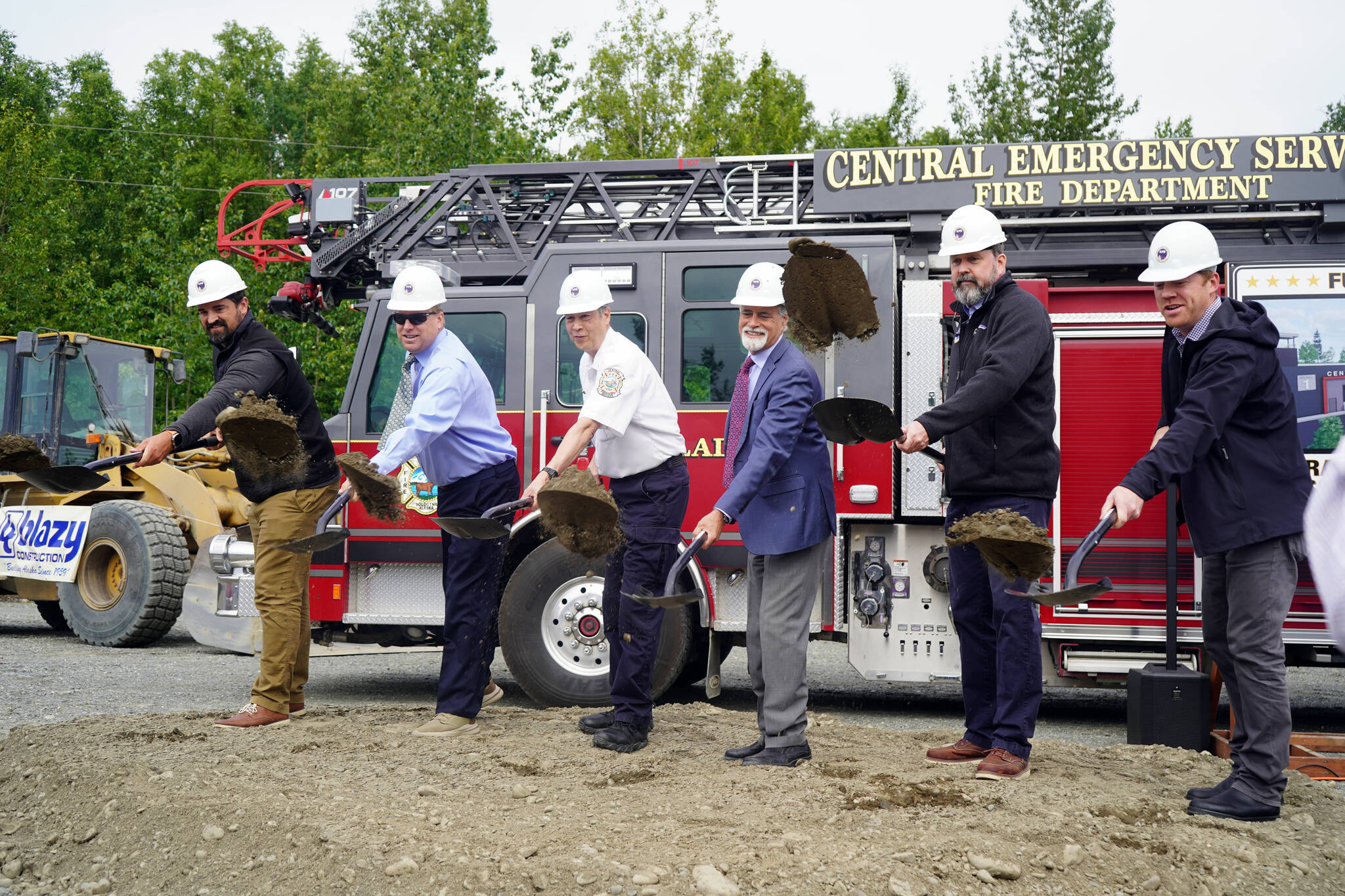 Central Emergency Services Chief Roy Browning and other dignitaries toss dirt into the air at a groundbreaking for the new Central Emergency Services Station 1 in Soldotna, Alaska, on Wednesday, July 24, 2024. (Jake Dye/Peninsula Clarion)