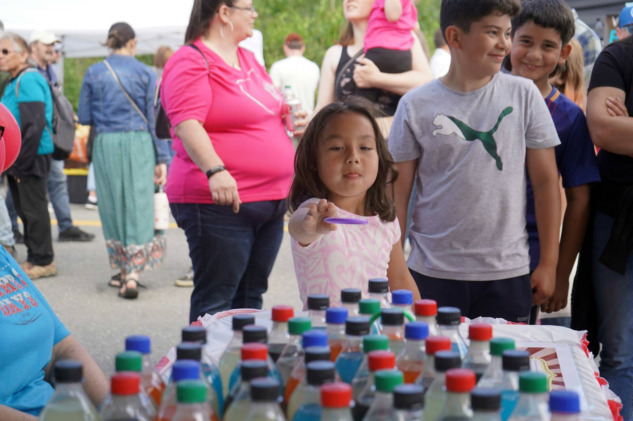 Children participate in a ring toss during the Progress Days Block Party at Parker Park in Soldotna, Alaska, on Saturday, July 27, 2024. (Jake Dye/Peninsula Clarion)