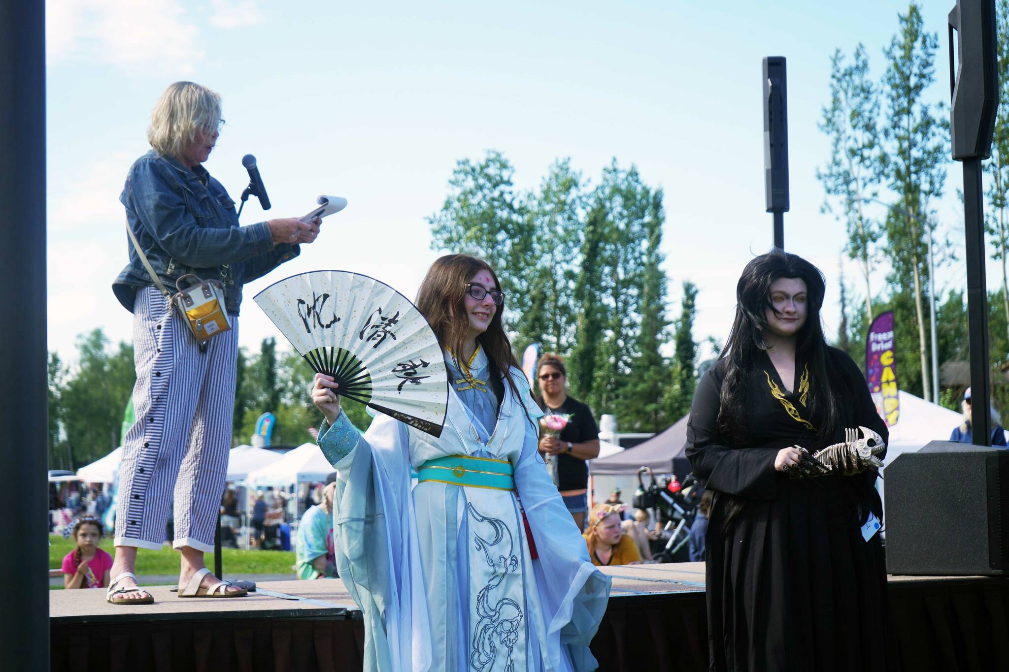 Zoe Nelson and Sarah Anne Sulzer show off their cosplay from Chinese novel/animation series “Heaven Official’s Blessing” during the Kenai Performers Cosplay Costume Contest at the Soldotna Progress Days Block Party in Parker Park in Soldotna, Alaska, on Saturday, July 27, 2024. Their cosplay earned “Best in Show.” (Jake Dye/Peninsula Clarion)