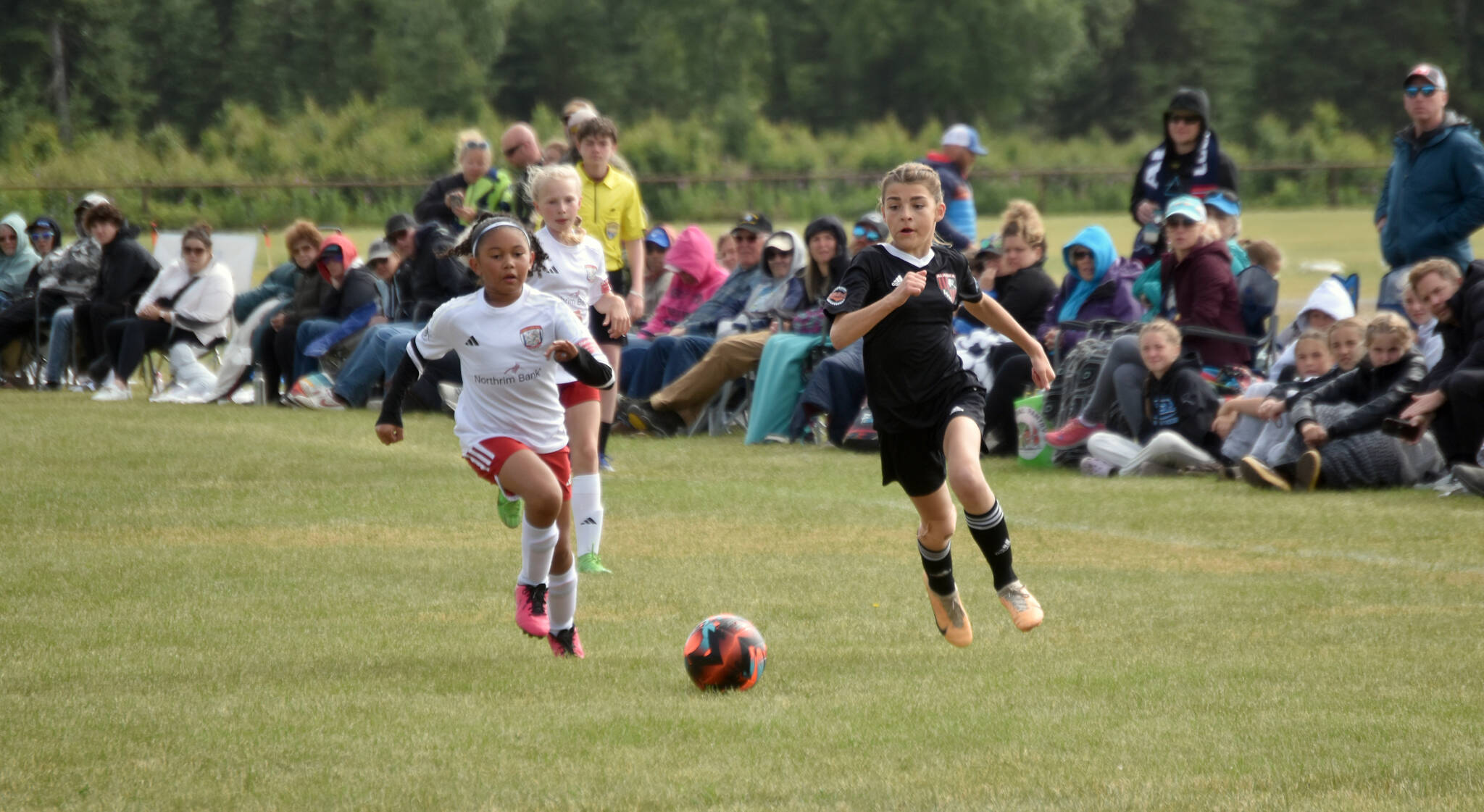 Heaven Newman of the Cook Inlet Soccer Club and Peyton Barber of the Kenai Kicks chase the ball Saturday, Aug. 3, 2024, at the Kenai Sports Complex in Kenai, Alaska, in a U13 Alaska Youth State Cup game. (Photo by Jeff Helminiak/Peninsula Clarion)