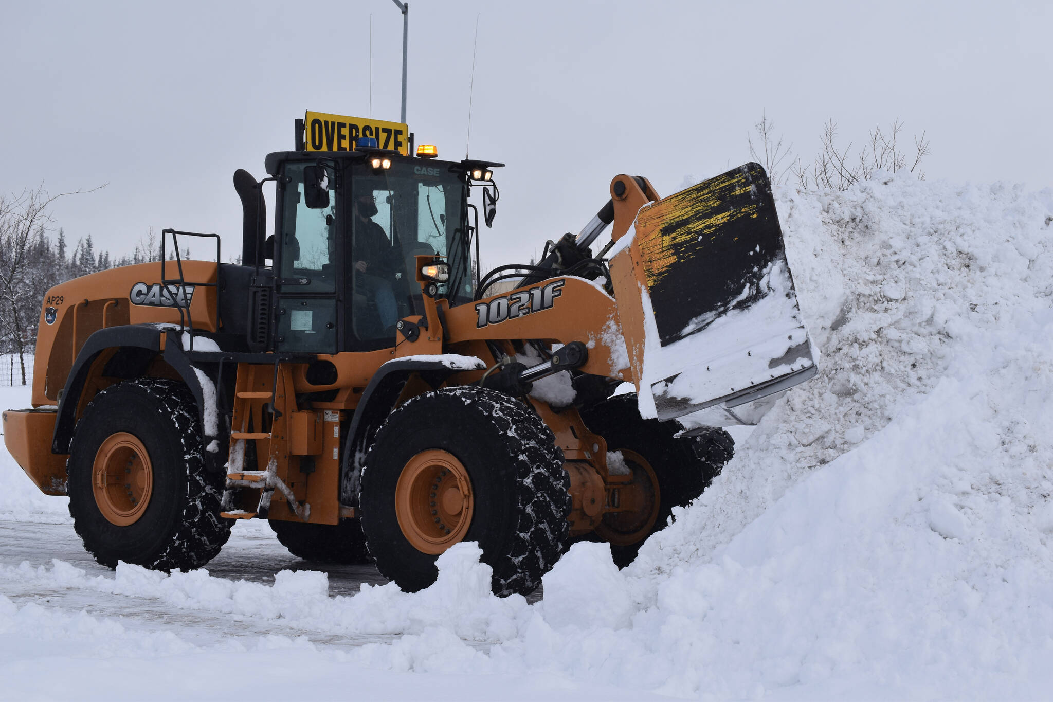 Snow is cleared from a parking lot at the Kenai Municipal Airport on Wednesday, Nov. 2, 2022 in Kenai, Alaska. (Jake Dye/Peninsula Clarion)