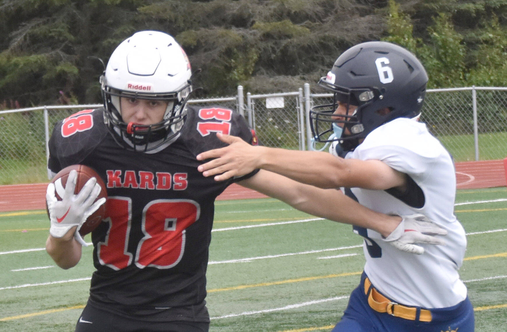 Kenai Central’s Aasen Campanella rushes the ball against Homer’s Austin Briscoe on Saturday, Aug. 17, 2024, at Ed Hollier Field at Kenai Central High School in Kenai, Alaska. (Photo by Jeff Helminiak/Peninsula Clarion)